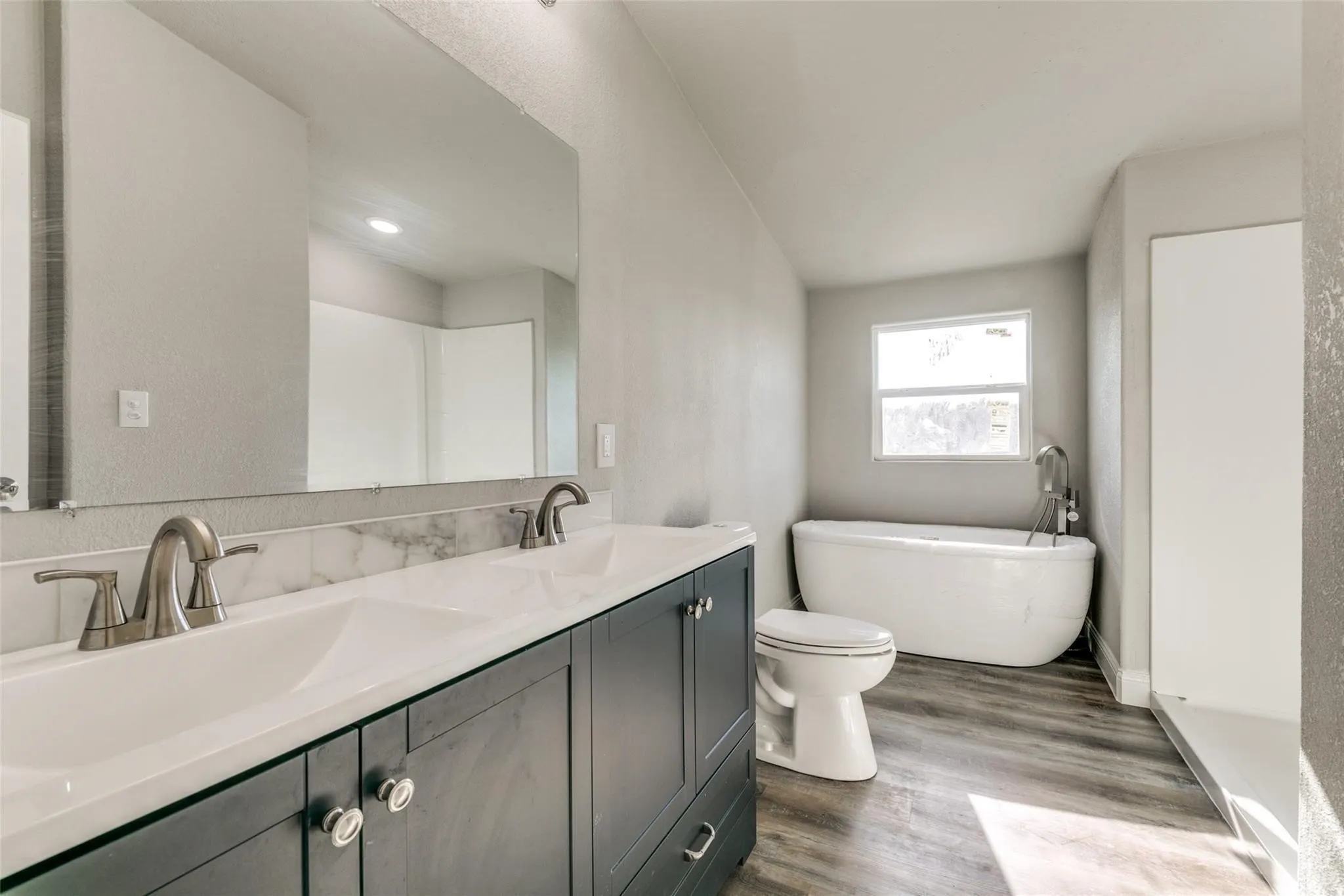 Master bathroom with freestanding tub, walk in shower, marbel countertops and brushed nickel fixtures.