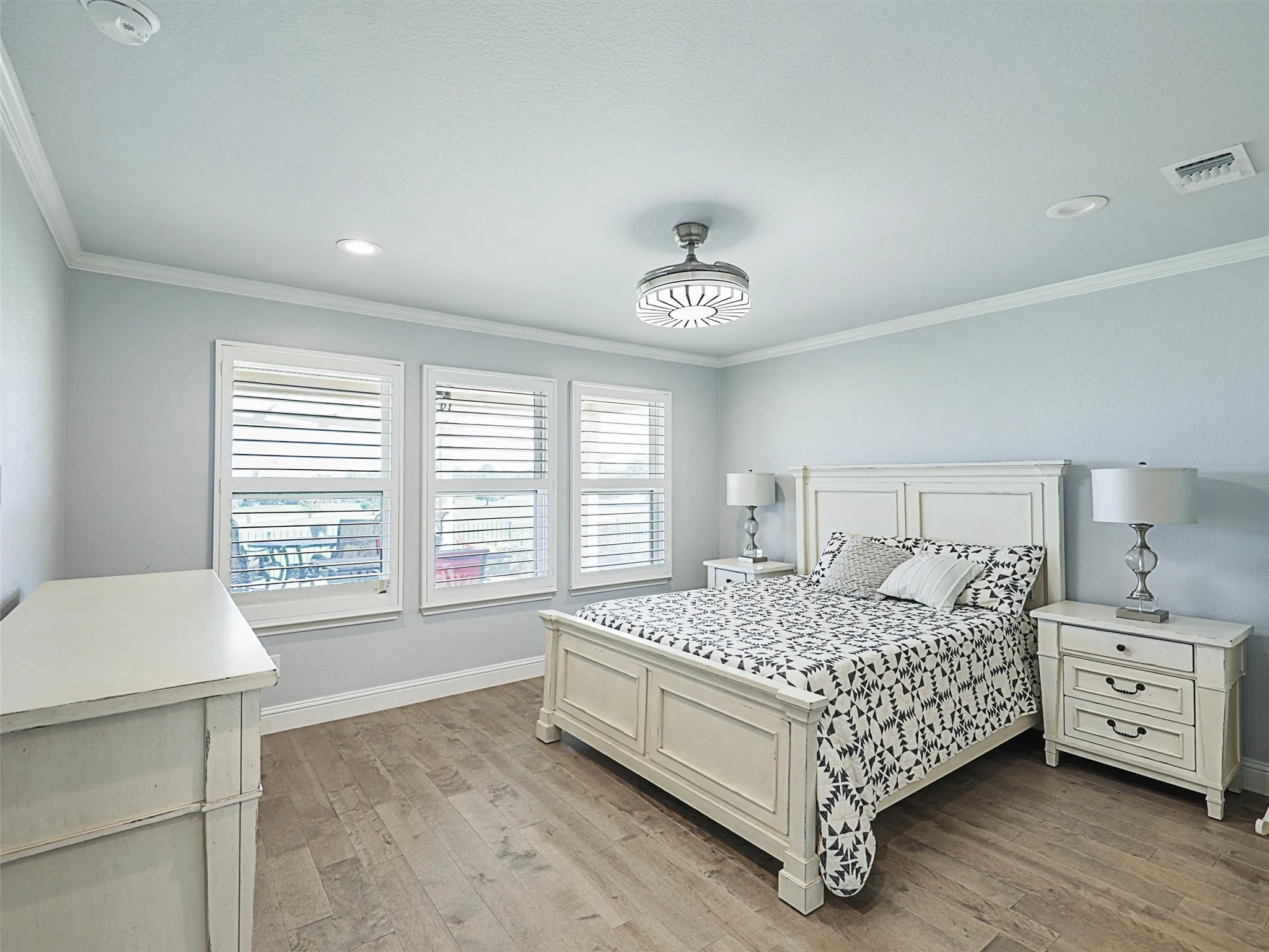 Primary Bedroom featuring LVP, Crown Molding and Shutters. Bedroom Furniture is negotiable with offer.