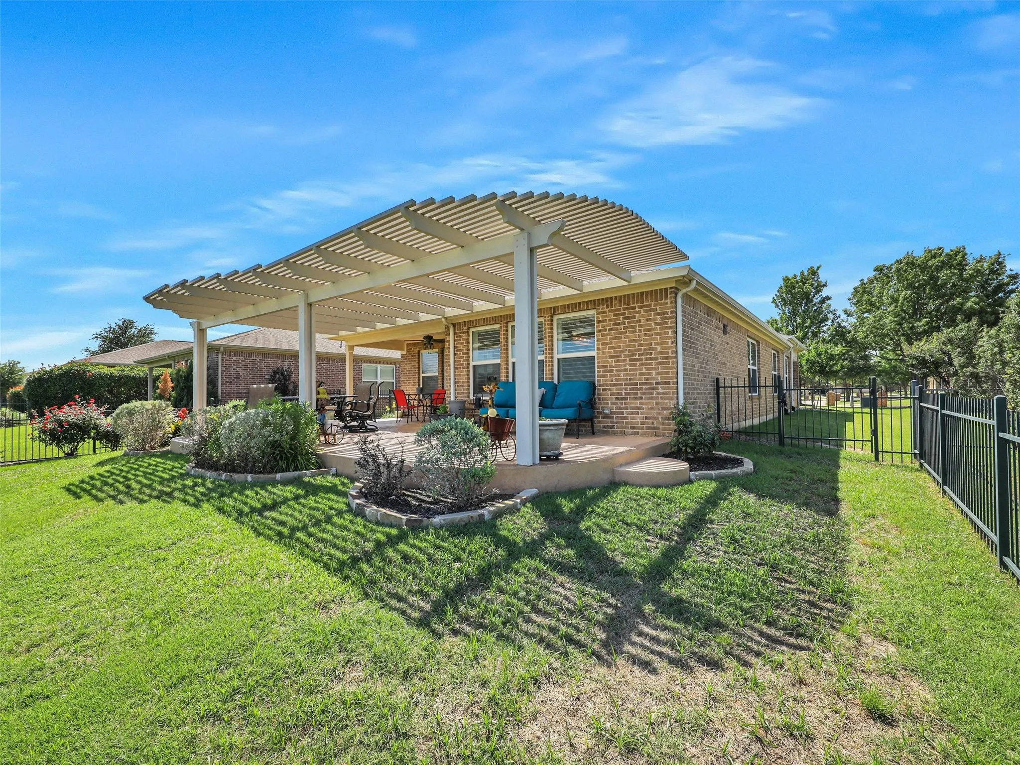 Rear view of house featuring a pergola, a patio area, and a yard