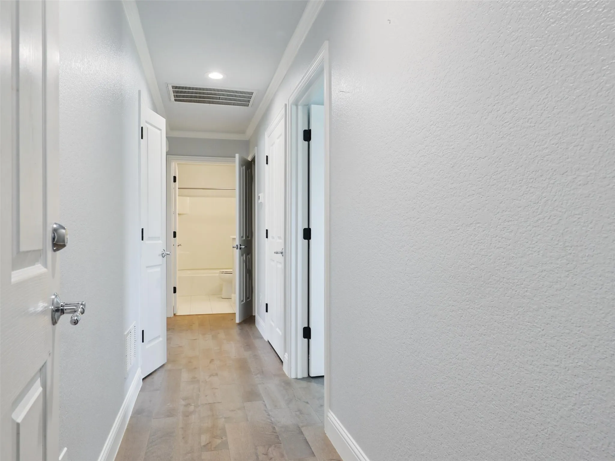 Hall from garage featuring two storage closets