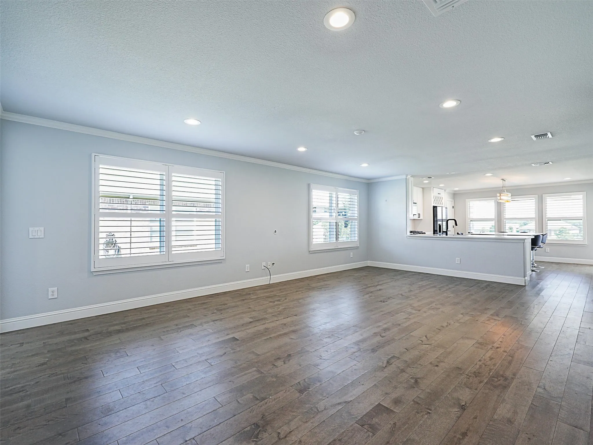 Living room with crown molding, neutral paint and LVP.