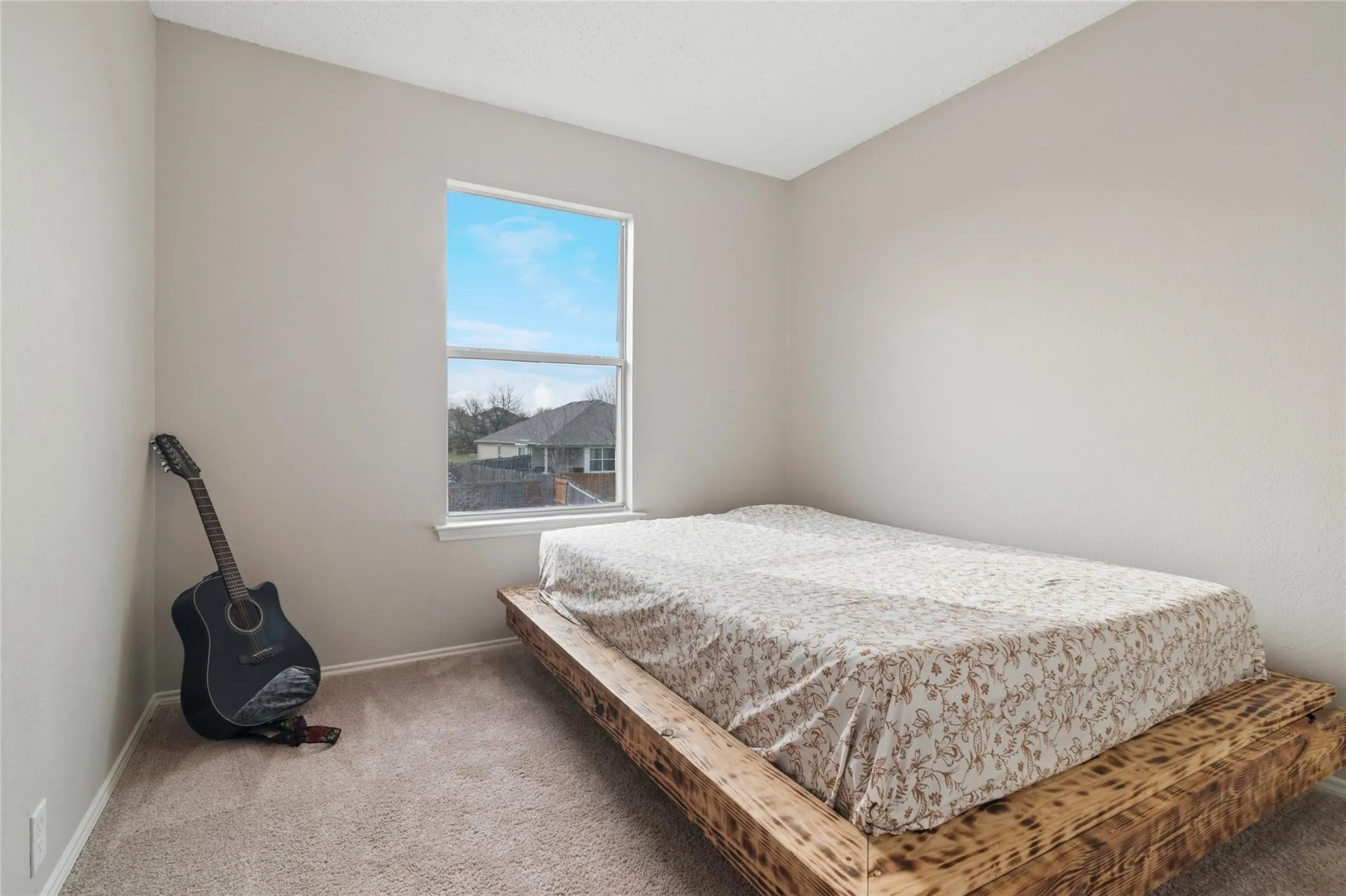 Wall-to-wall carpeting and a single window with white trim
