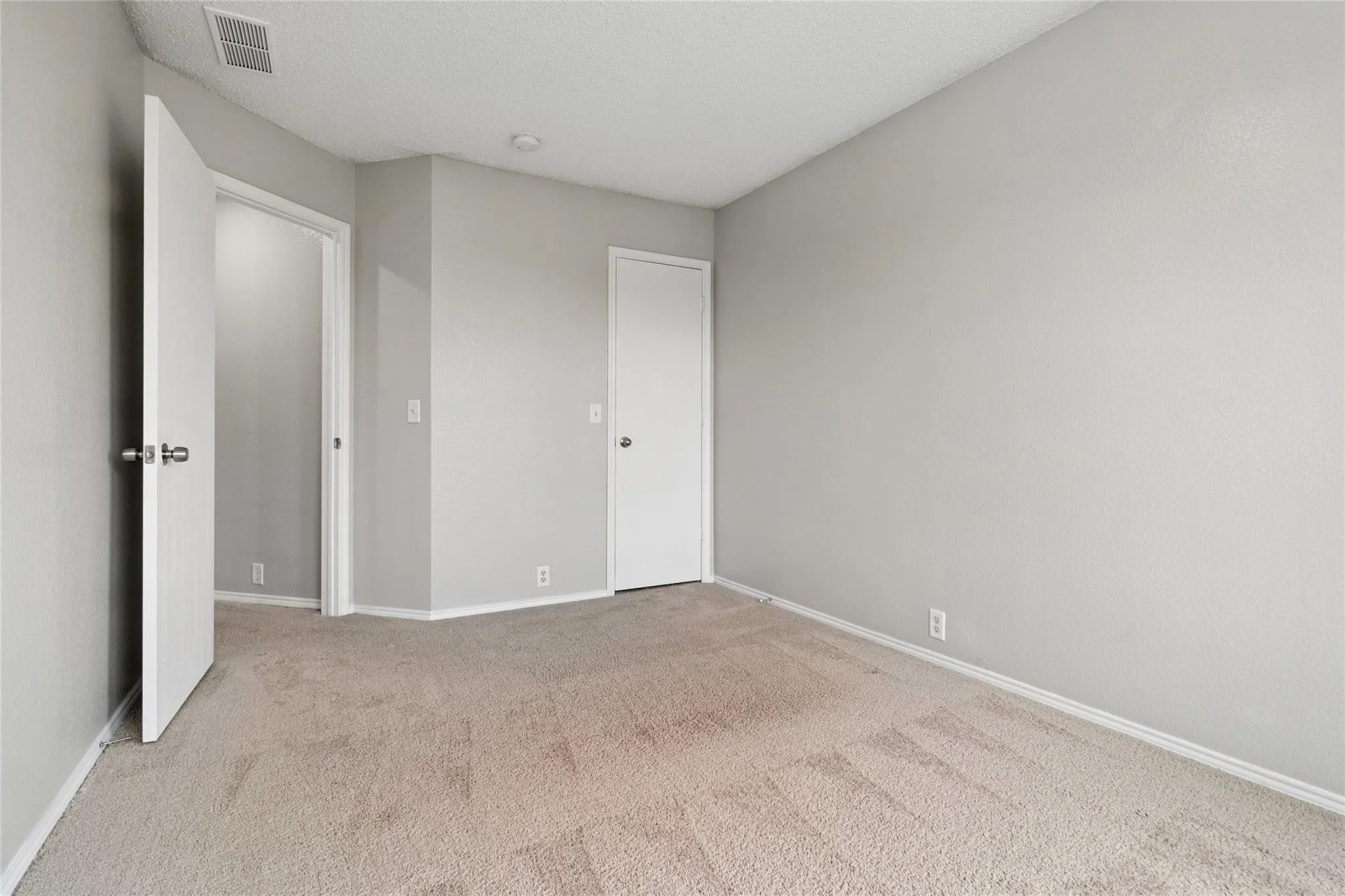 Light-toned carpet flooring, neutral painted walls, and white trim throughout