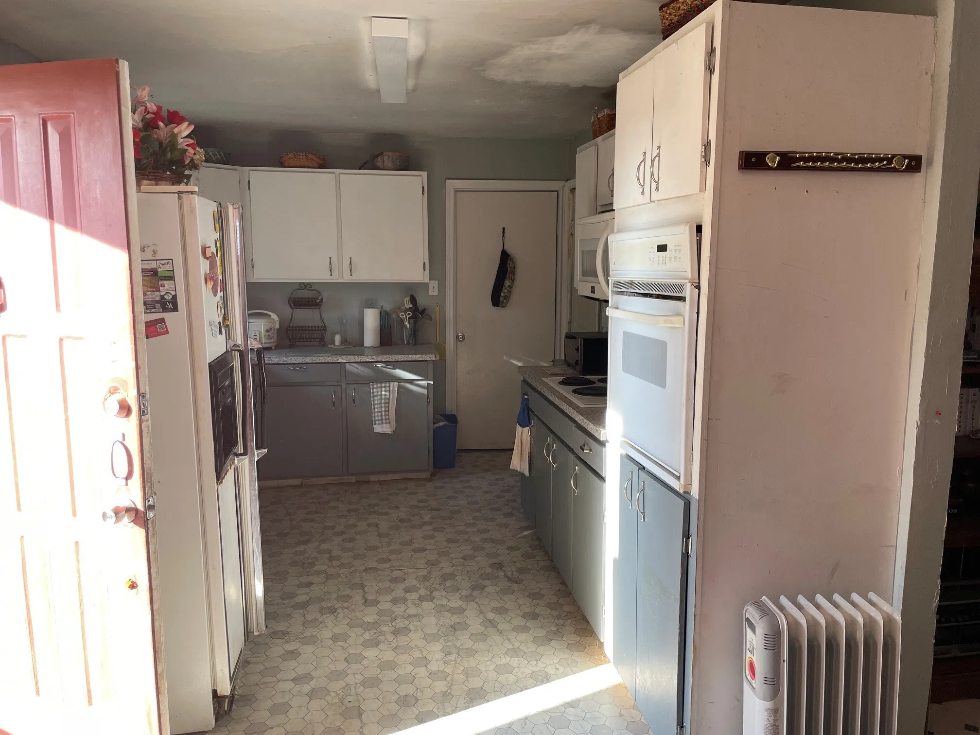 Kitchen featuring hexagon-patterned flooring, white upper cabinetry, and gray lower cabinetry