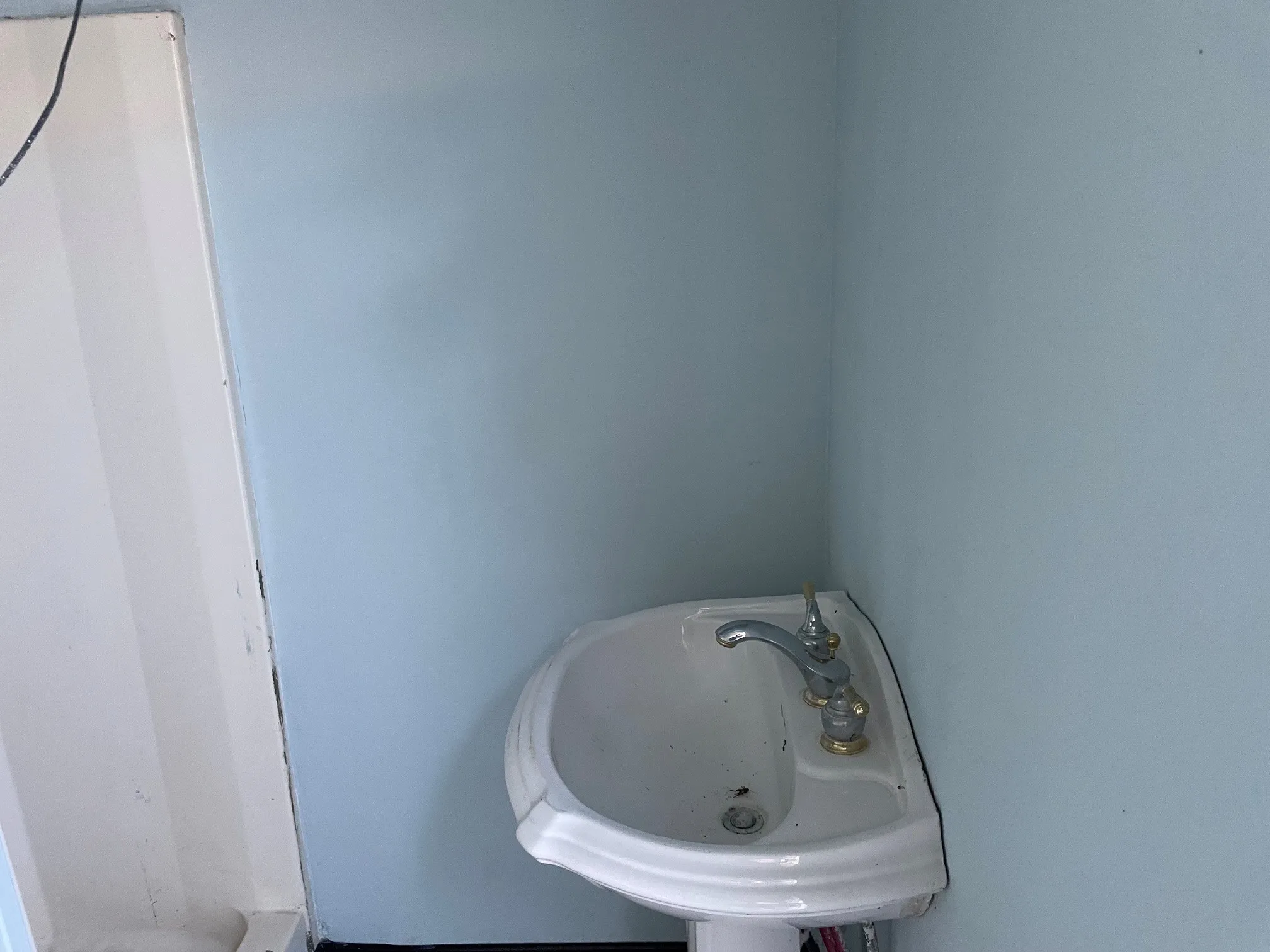 Corner pedestal sink with a dual-handle faucet
