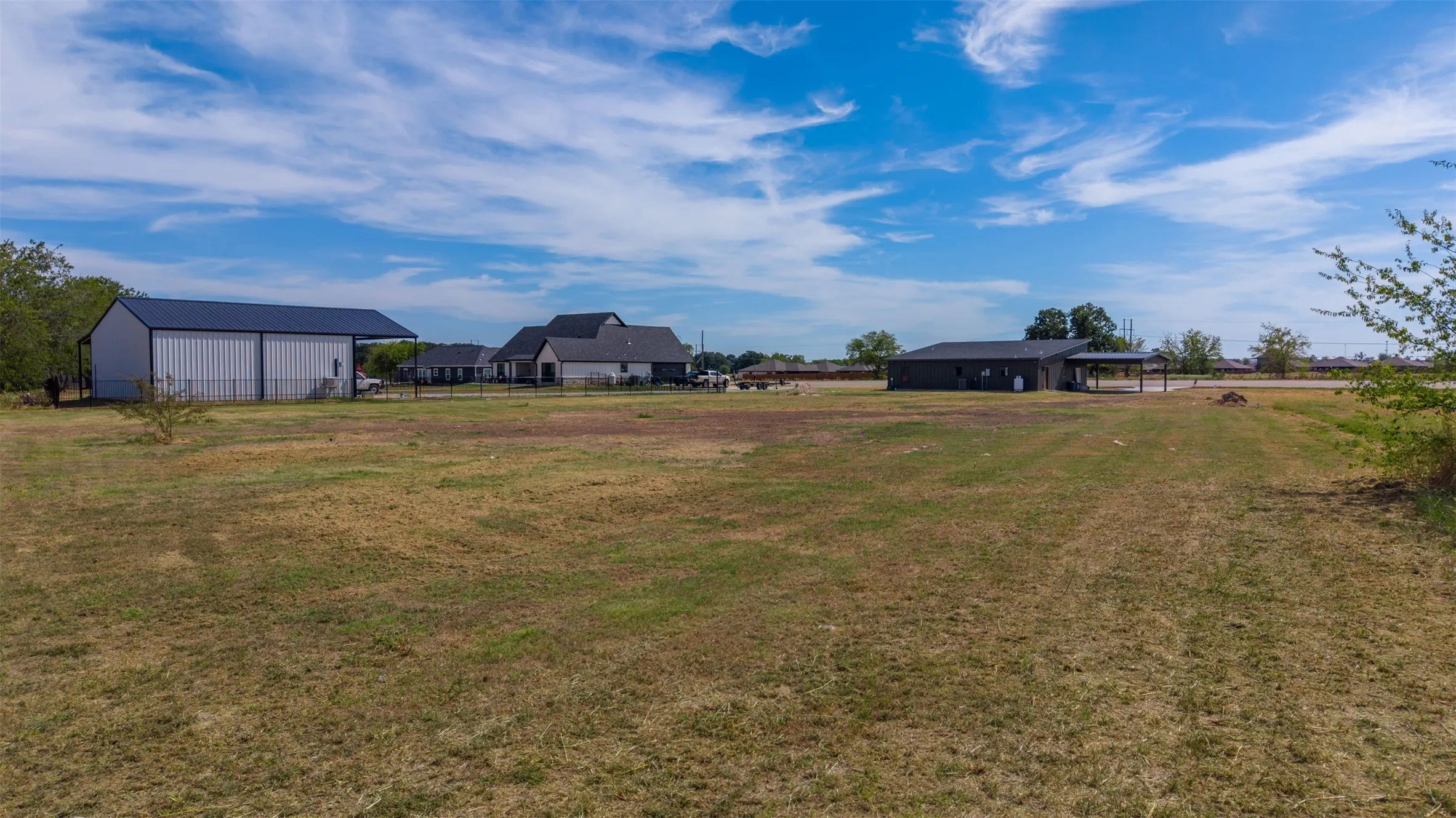 Expansive lot featuring a large metal barn and additional outbuilding