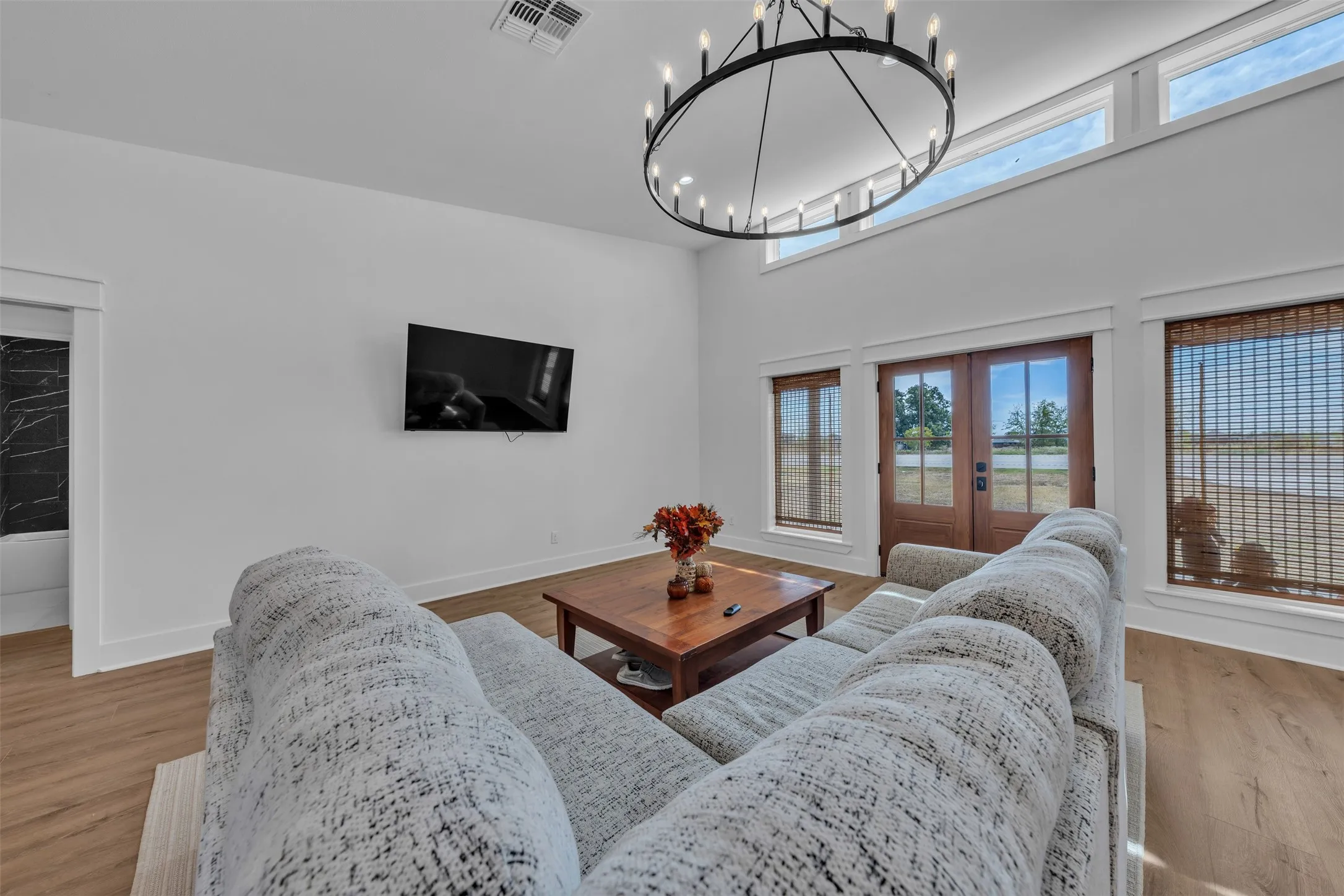 Spacious living room flooded with natural light through expansive multi-panel glass doors and transom windows