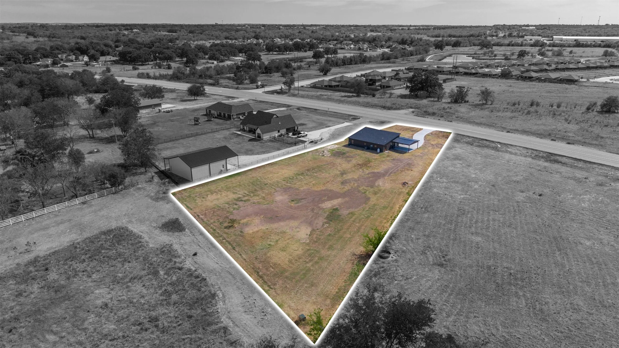 Expansive lot featuring a single-story residence with a detached carport and a paved driveway