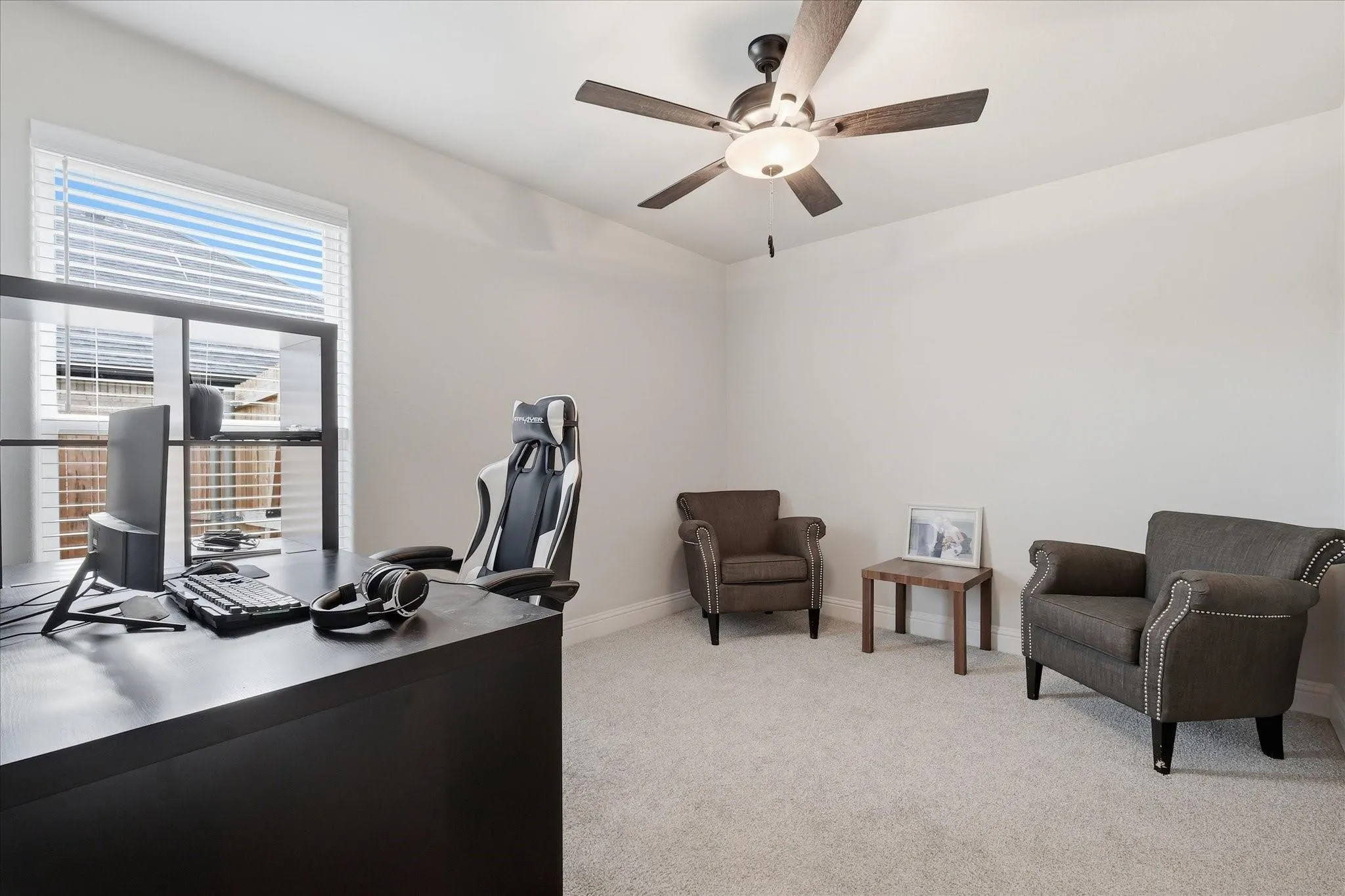 Recessed lighting, wood-finish ceiling fan, window with horizontal blinds, neutral wall paint, and light-colored carpeting