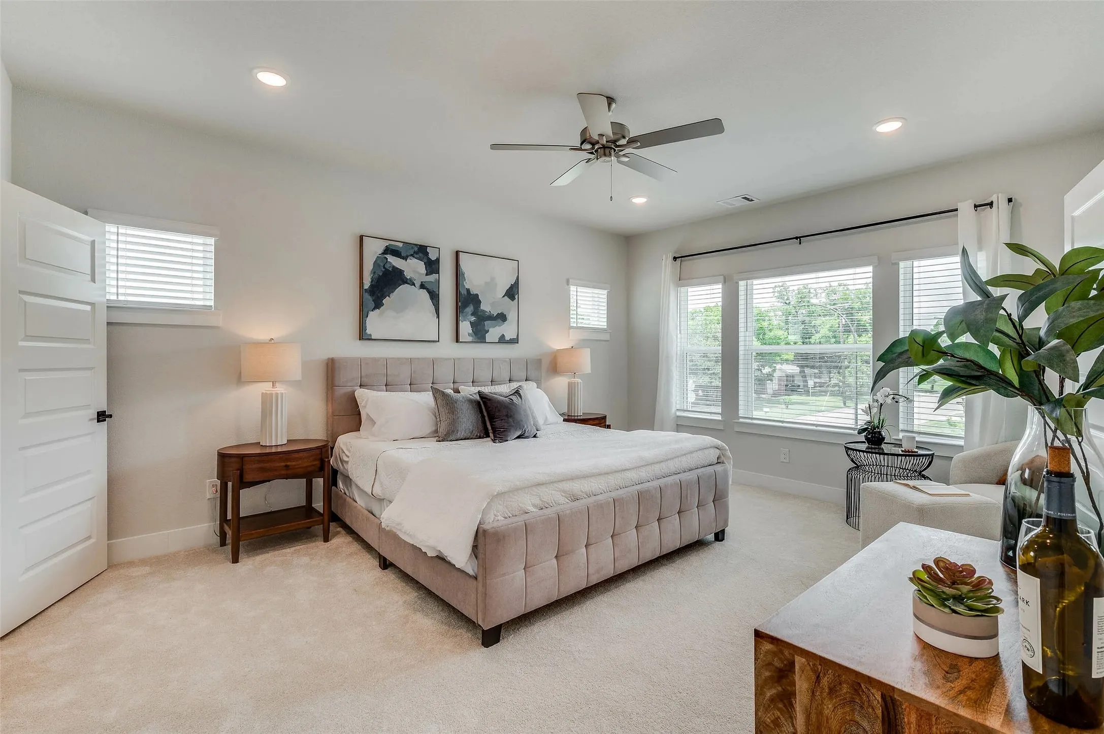 Recessed lighting, ceiling fan, multiple windows with blinds, light-colored carpeting, and a white paneled door