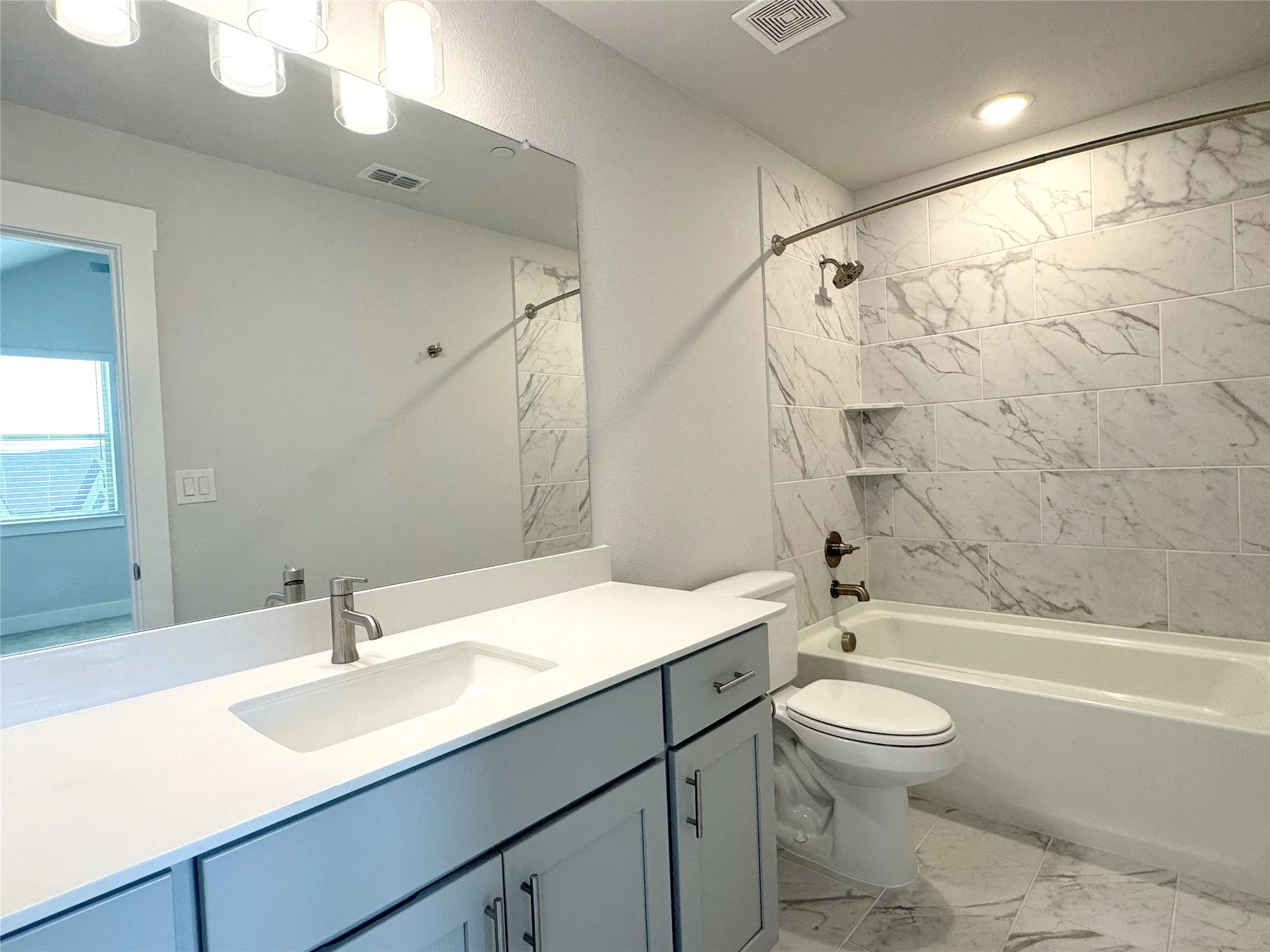 Bathroom featuring a white bathtub, toilet, and vanity with a rectangular sink