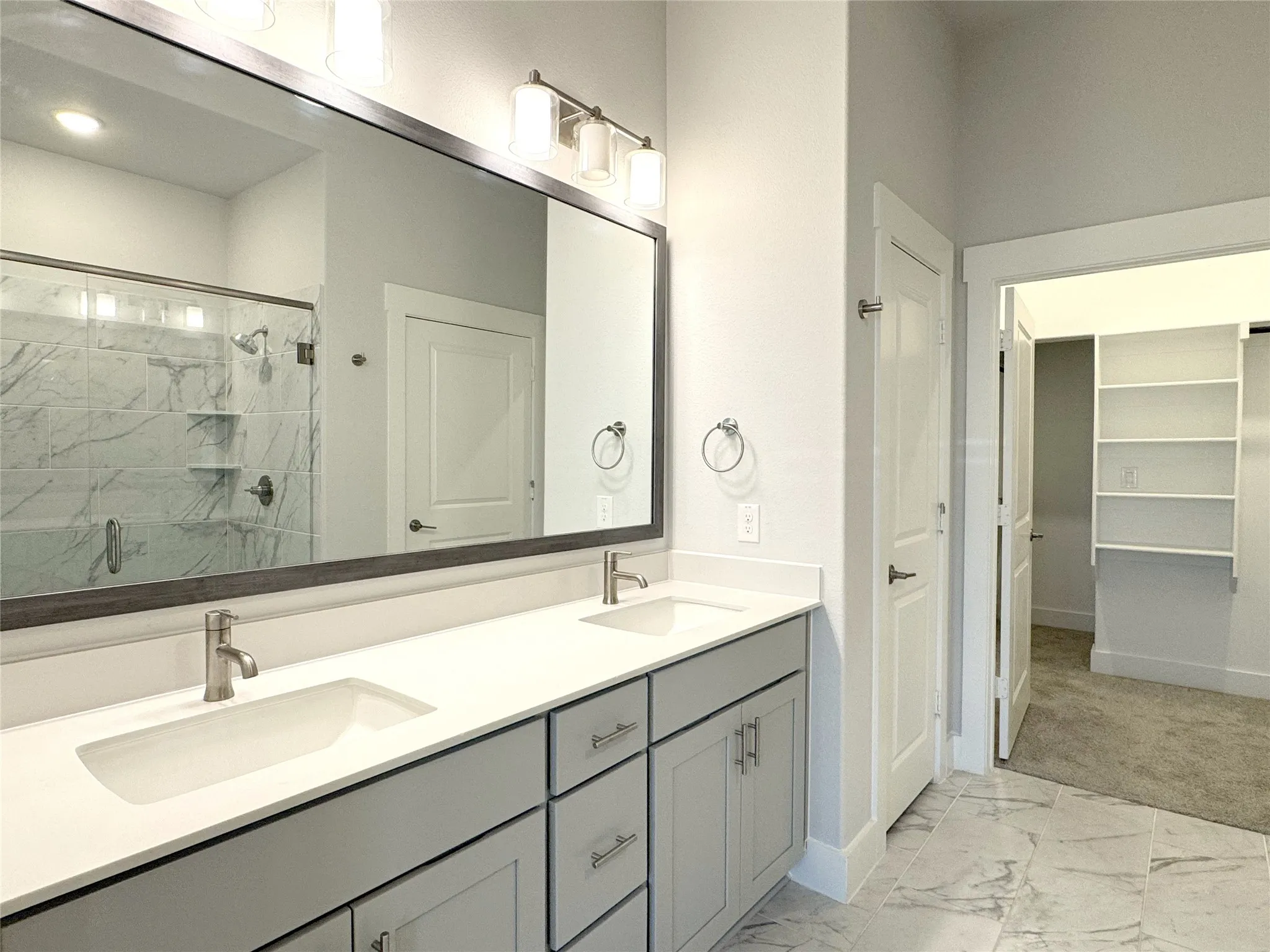 Double vanity with light gray cabinetry, brushed nickel hardware, and a white countertop