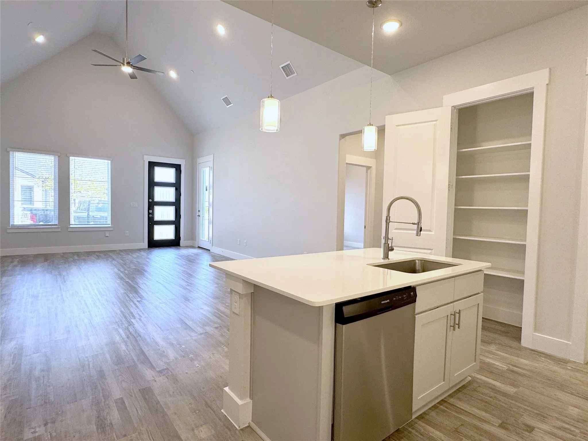 Kitchen island featuring a stainless steel sink, gooseneck faucet, and integrated dishwasher