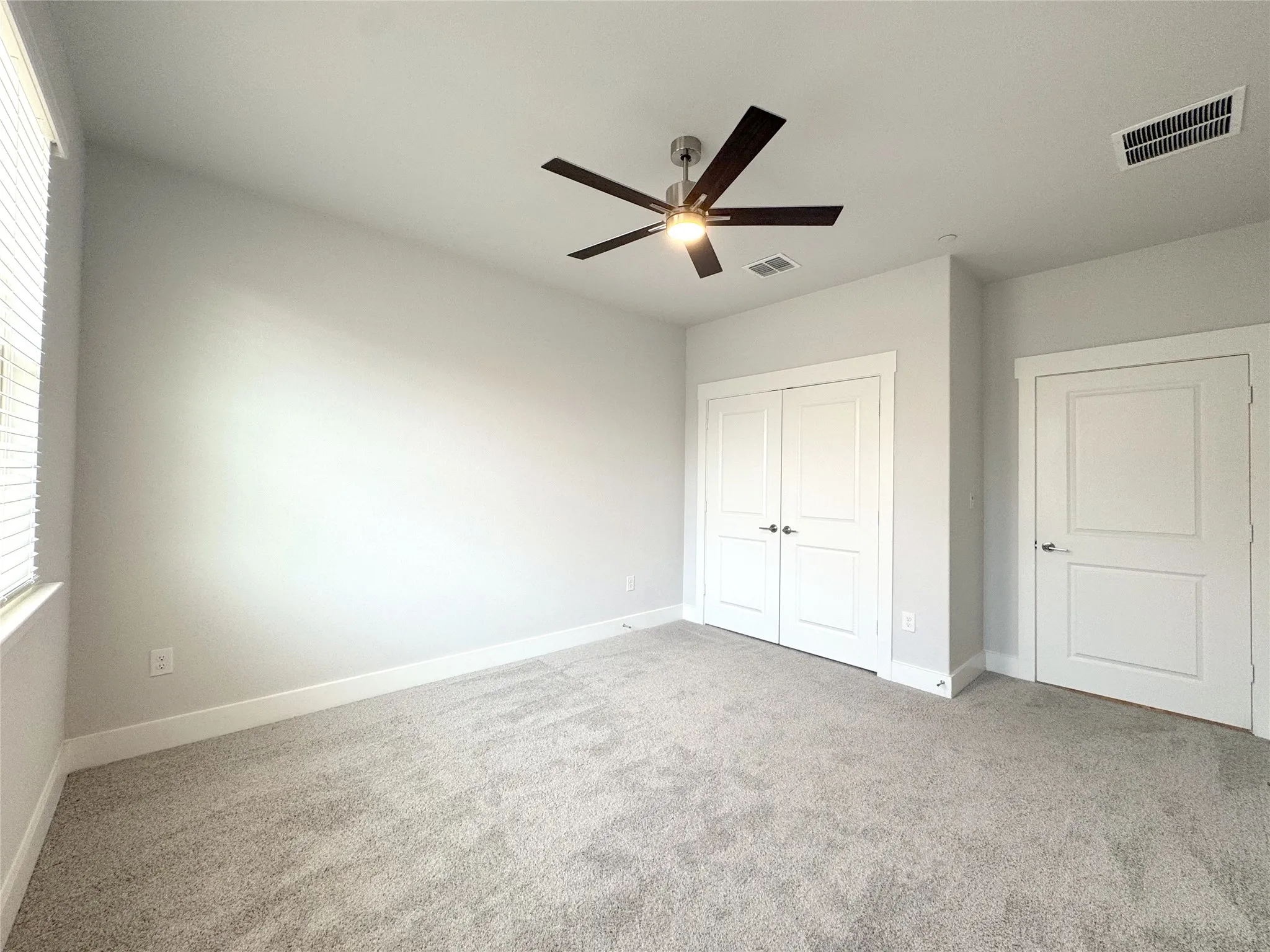 Second bedroom room featuring a ceiling fan, window with blinds, recessed lighting, and two panel doors
