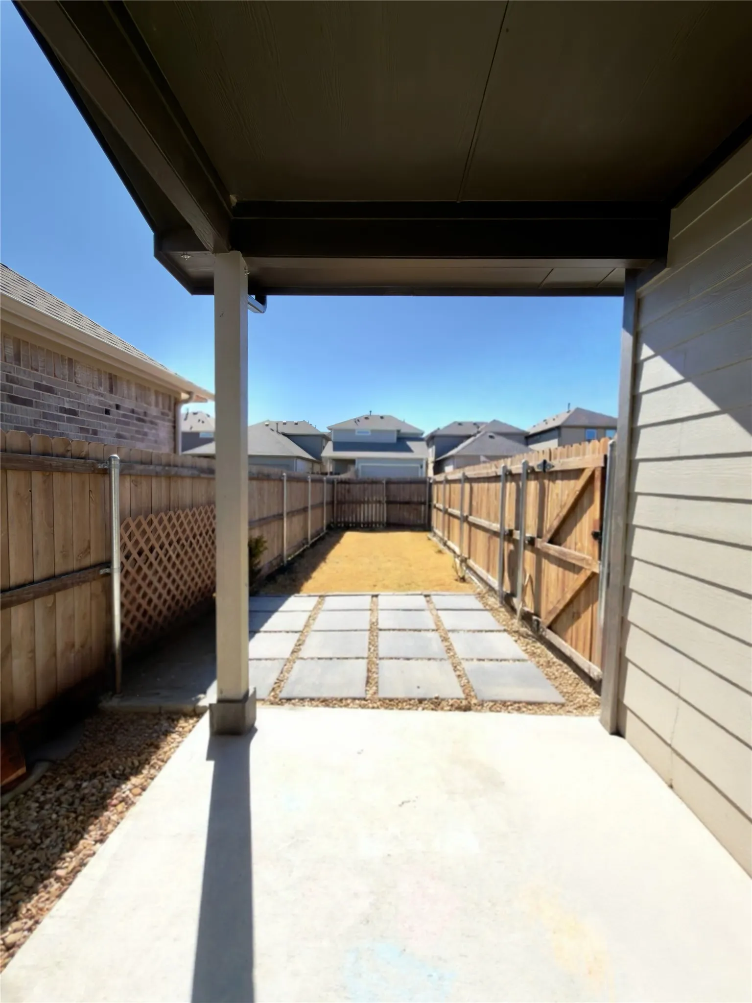 Fenced backyard featuring a patio area and a residential view
