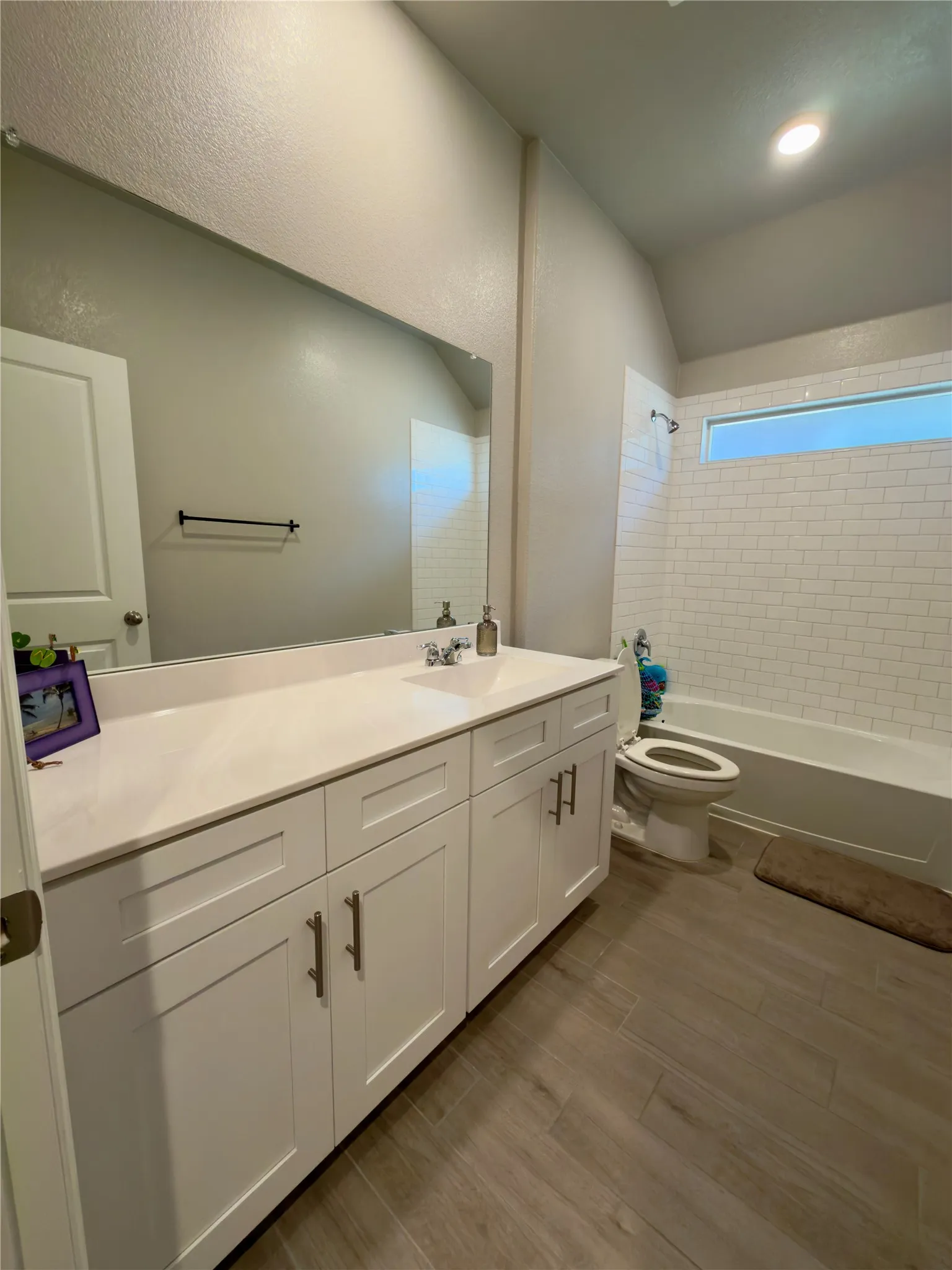 Full bath with vanity, dark wood-type flooring, and shower / bathtub combination