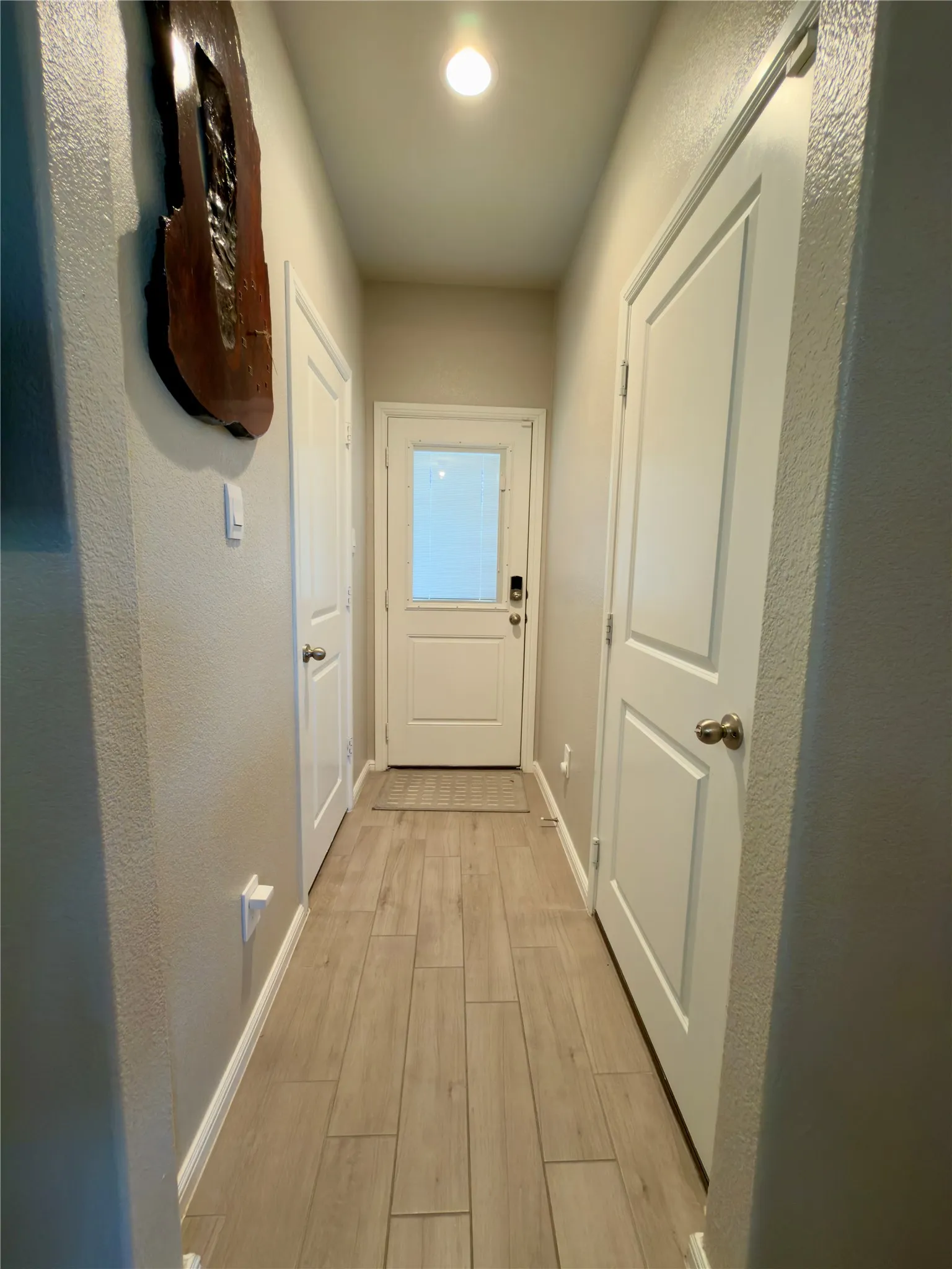Entryway with wood finished floors and a textured wall
