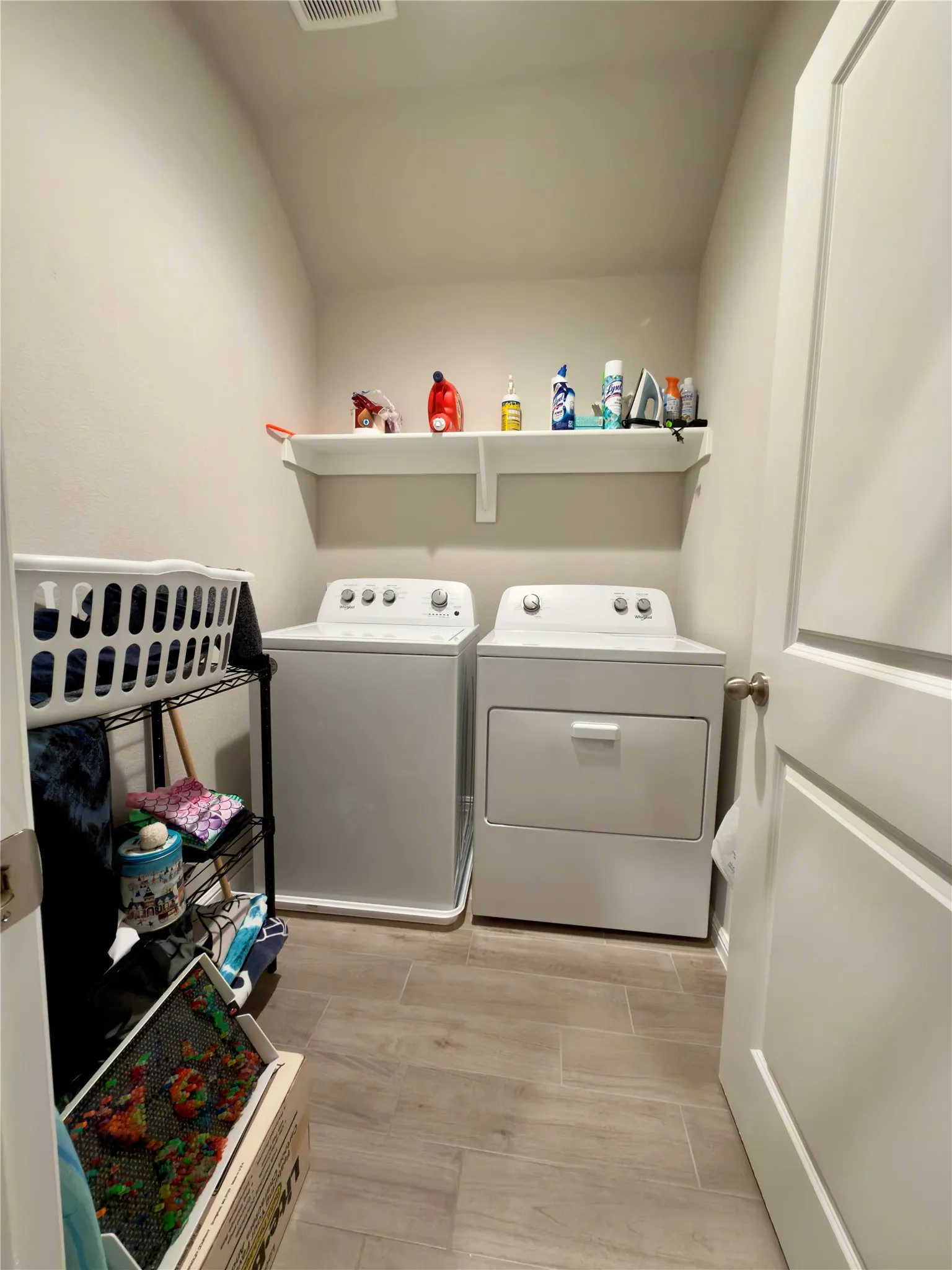 Laundry room featuring washer and clothes dryer, light wood-style flooring, and lofted ceiling