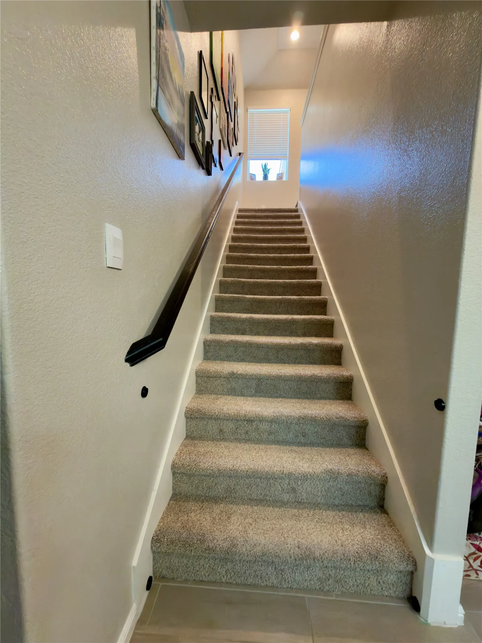 Stairway featuring baseboards and a textured wall