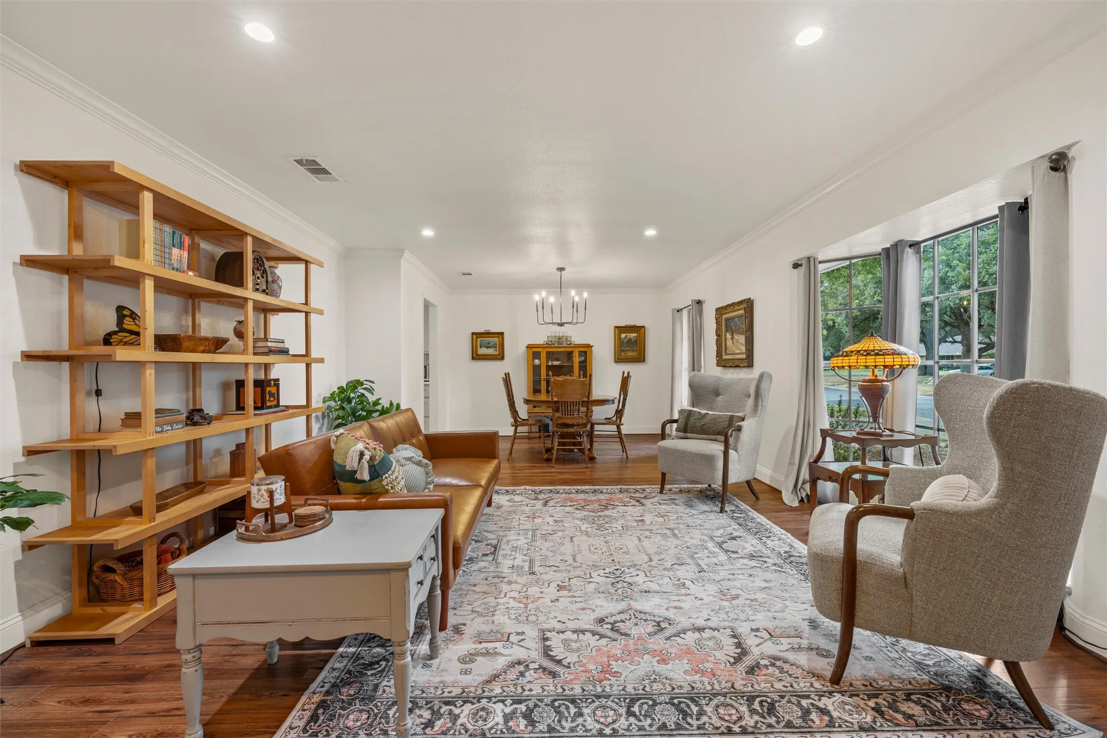 Recessed lighting, wood-finish flooring, a built-in shelving unit, a dining area, and a bay window