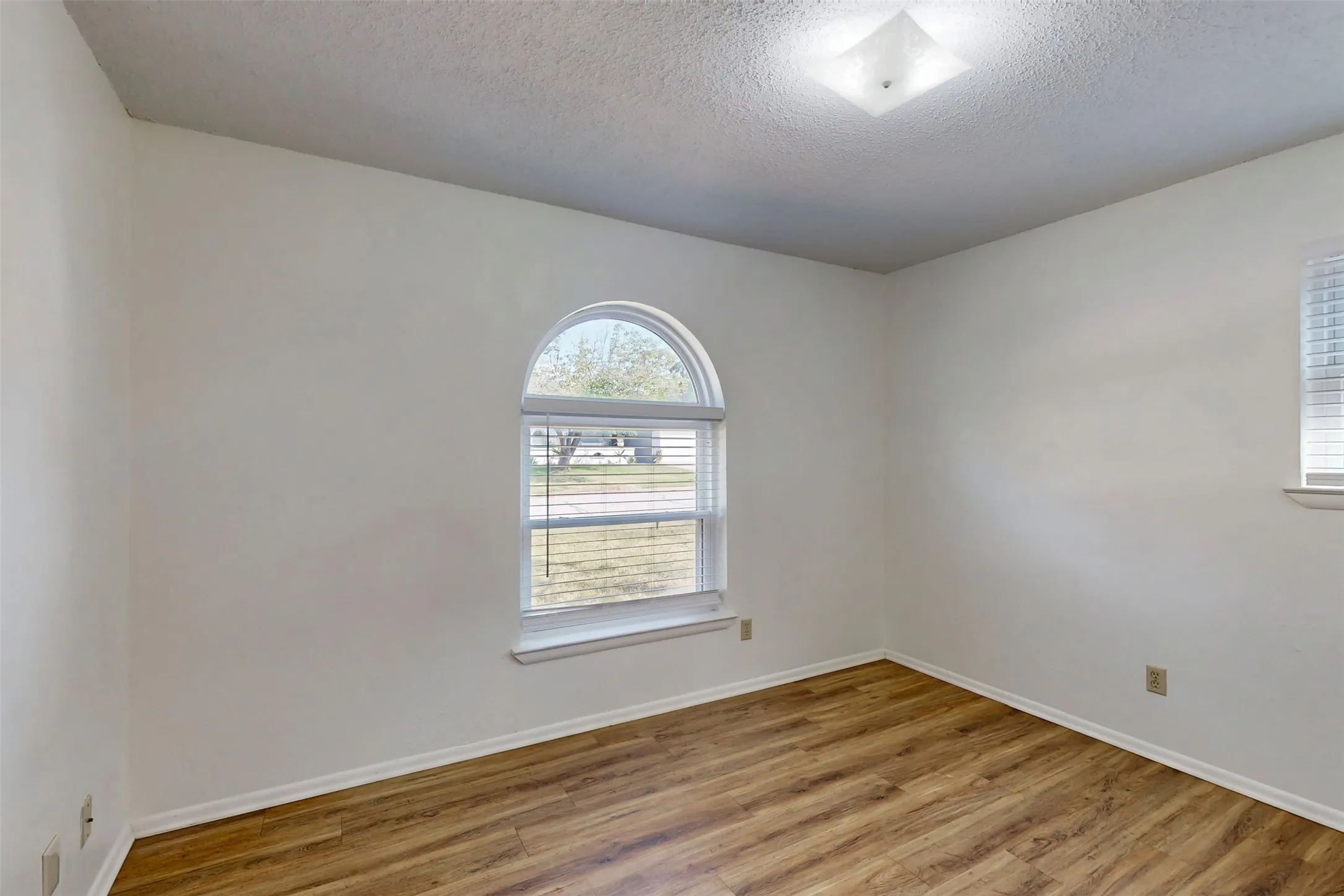 Bedroom 3 also has an arched window and looks out to the front yard.