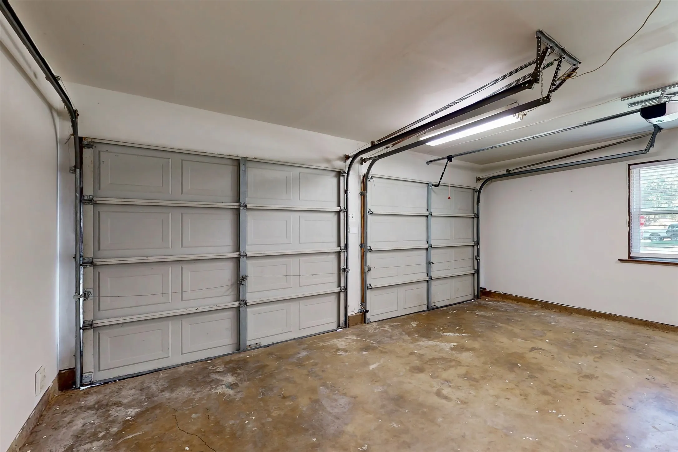 Two-car garage with separate garage doors. Electric opener on the right side was recently added, and the interior is freshly painted!