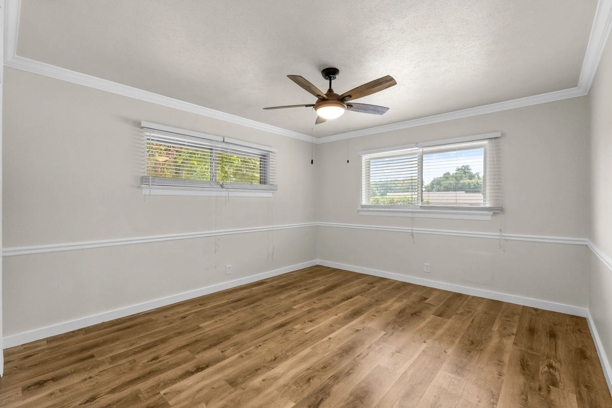 Wood-finish flooring with crown molding and chair rail detailing