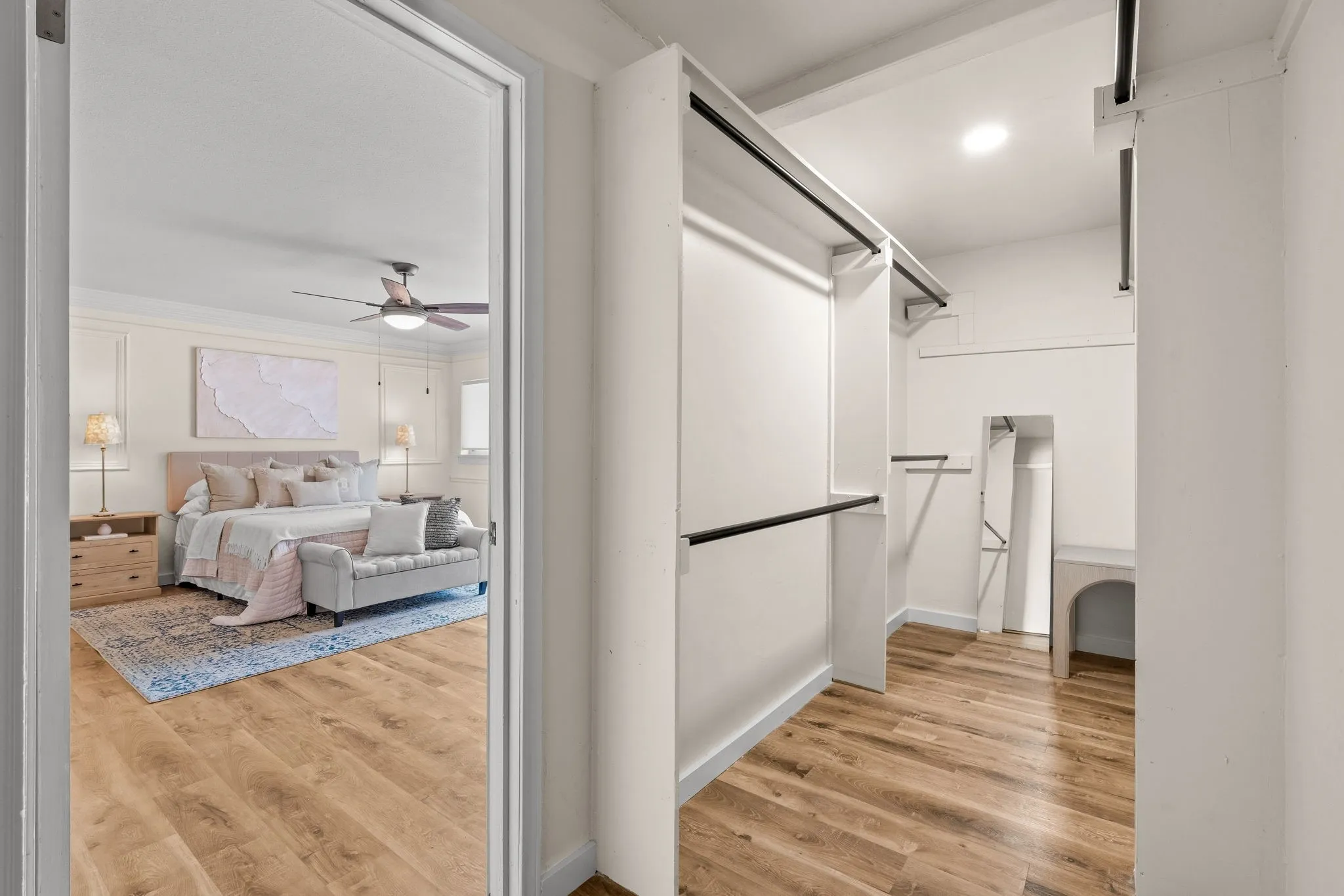 Walk-in closet with wood-finish flooring and built-in shelving