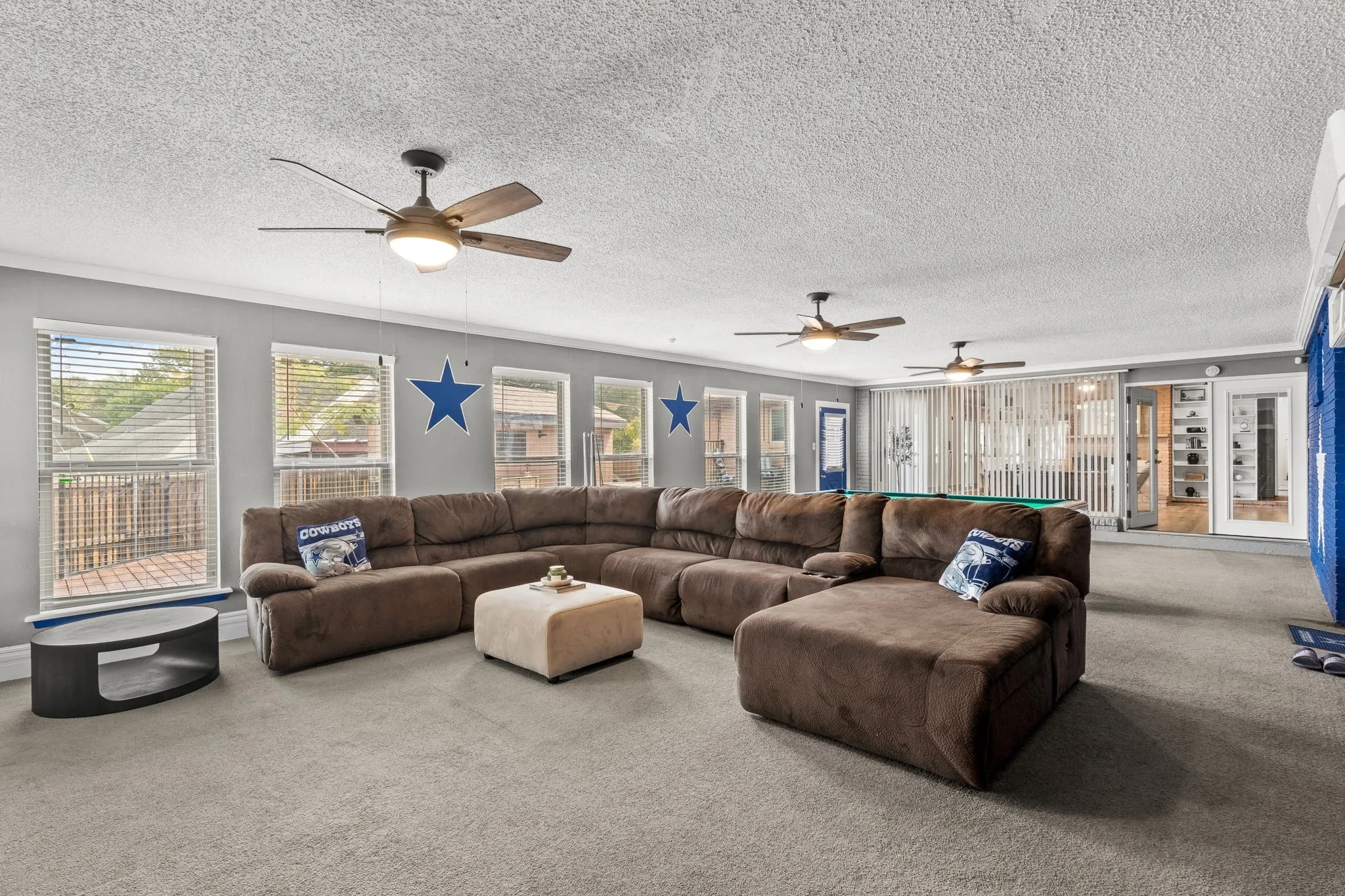 Spacious interior featuring carpet flooring and multiple windows with blinds