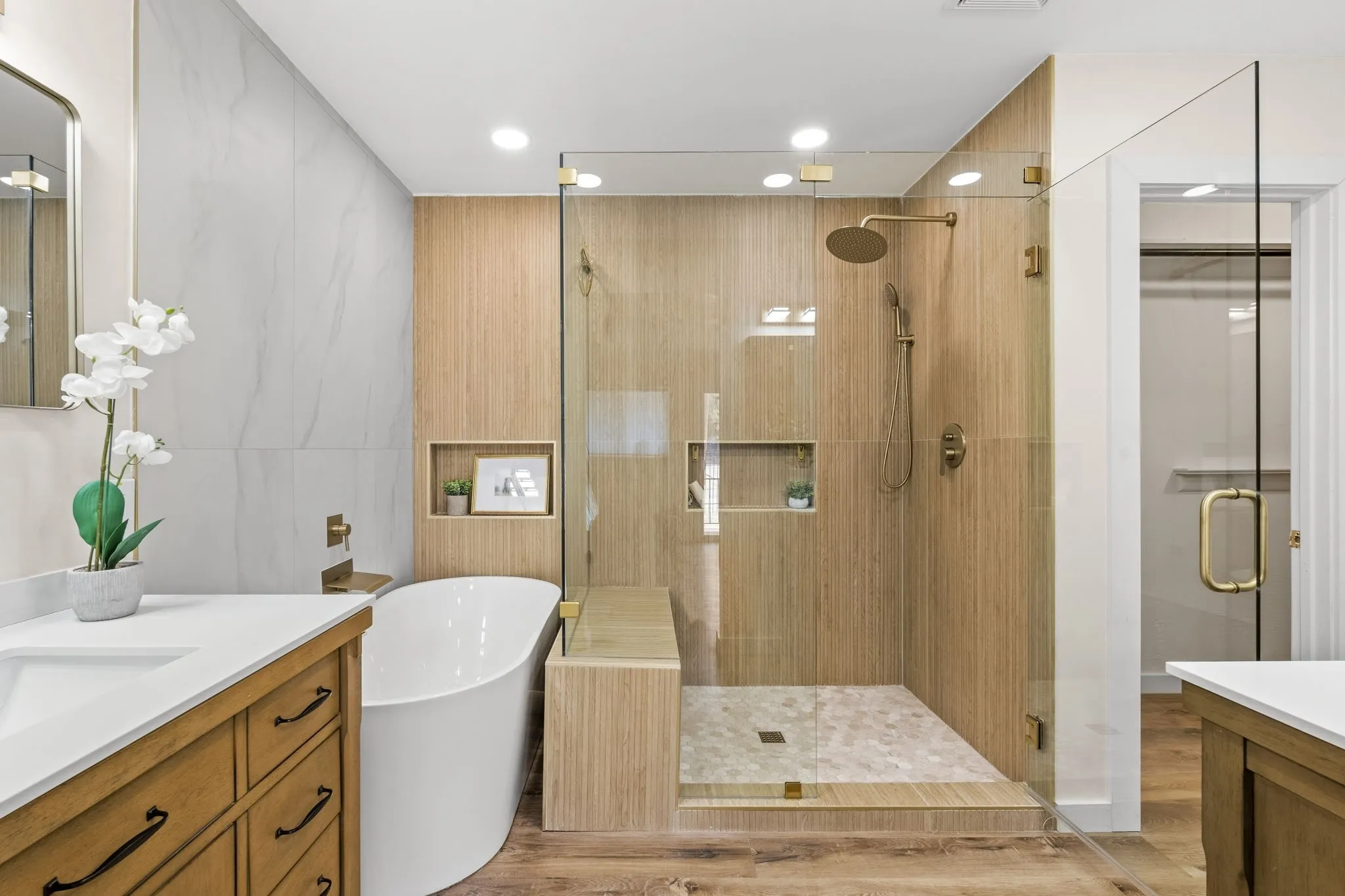 Walk-in shower with clear glass enclosure and gold-toned fixtures