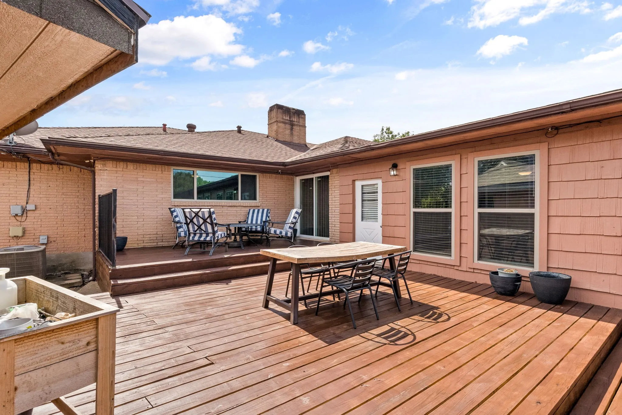 Multi-level wood deck with a brick and shingle exterior
