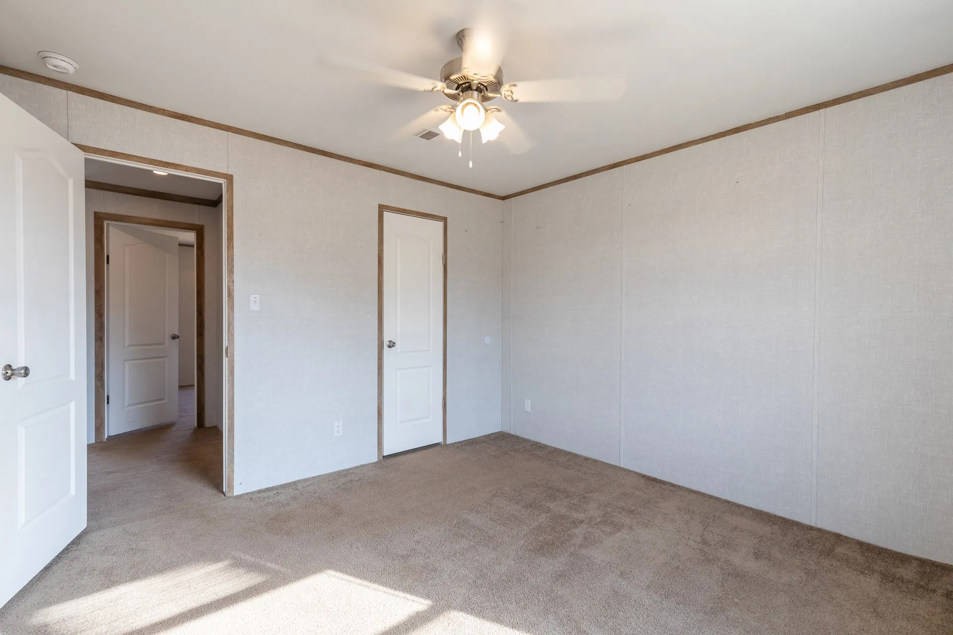 Carpeted flooring with white wall panels and wood-finish trim