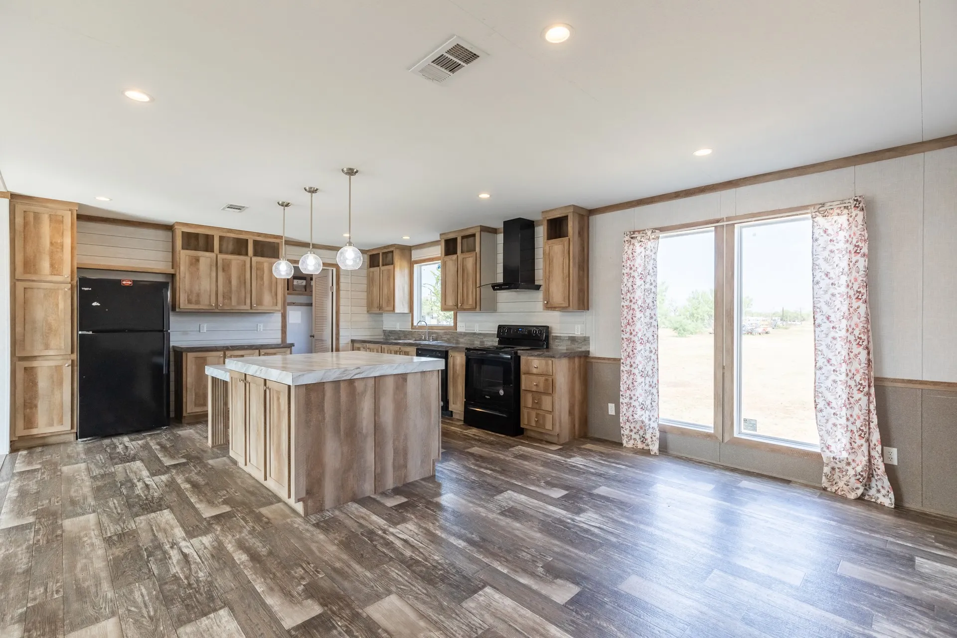 Expansive yard featuring a mature tree, a dark-colored storage shed, and a privacy fence