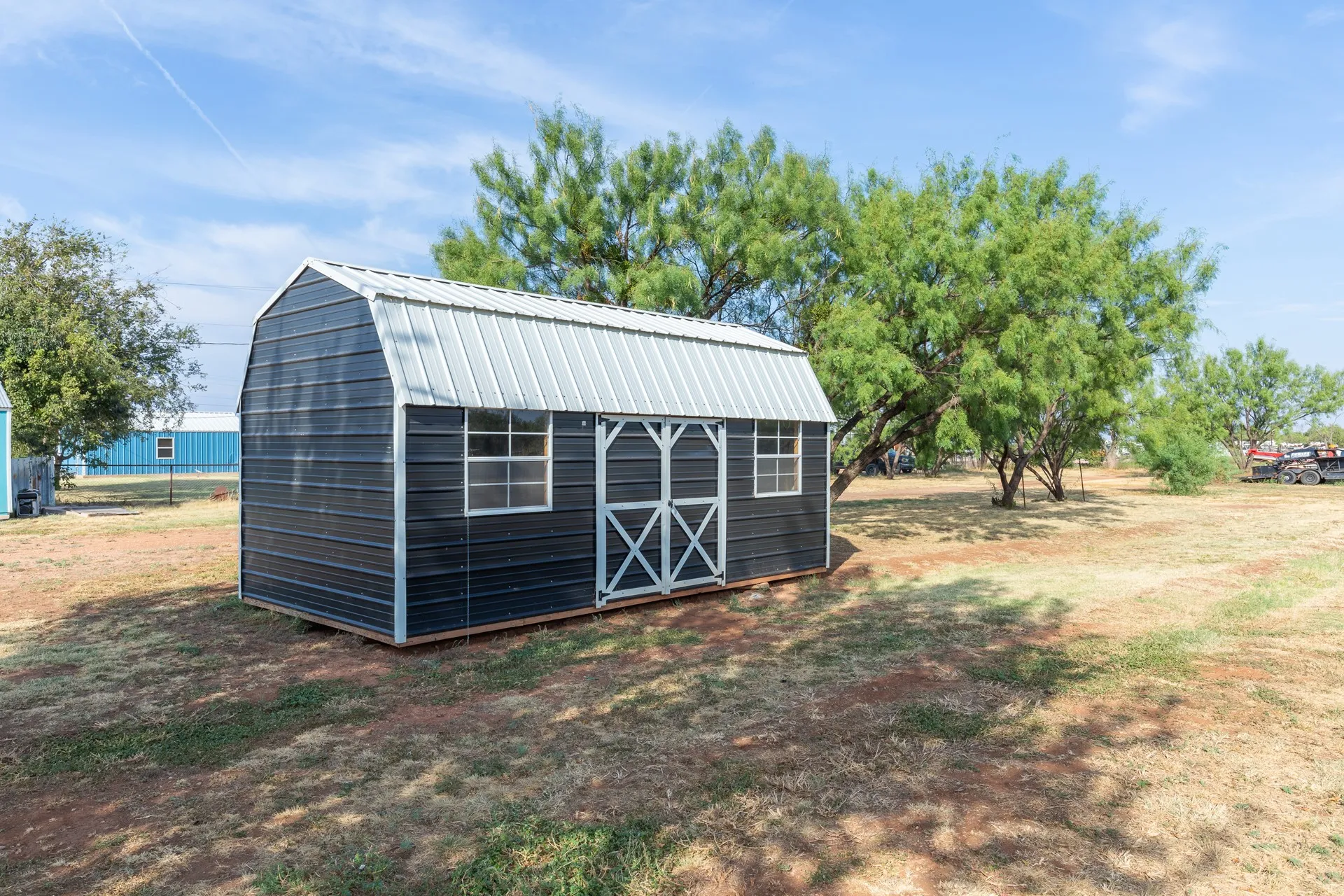 Single-story brown residence with a metal roof and an attached carport