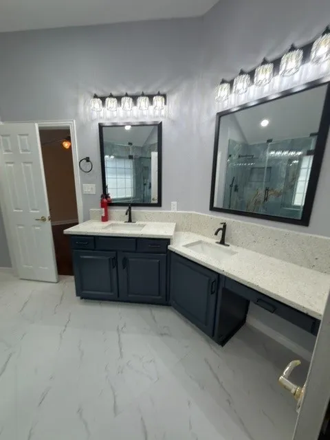 Dual vanities with integrated sinks, granite countertops, and dark cabinetry