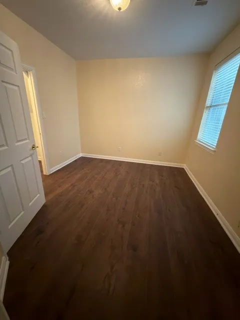 Wood-finish flooring, neutral wall tones, and overhead lighting