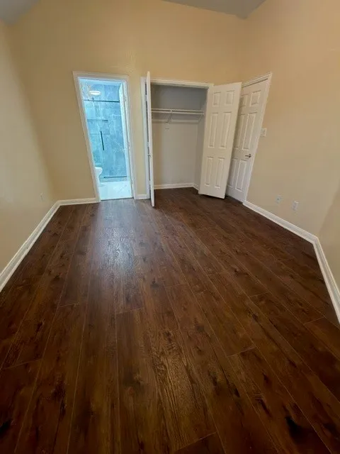 Wood-finish flooring, vaulted ceiling, and an integrated closet with bi-fold doors