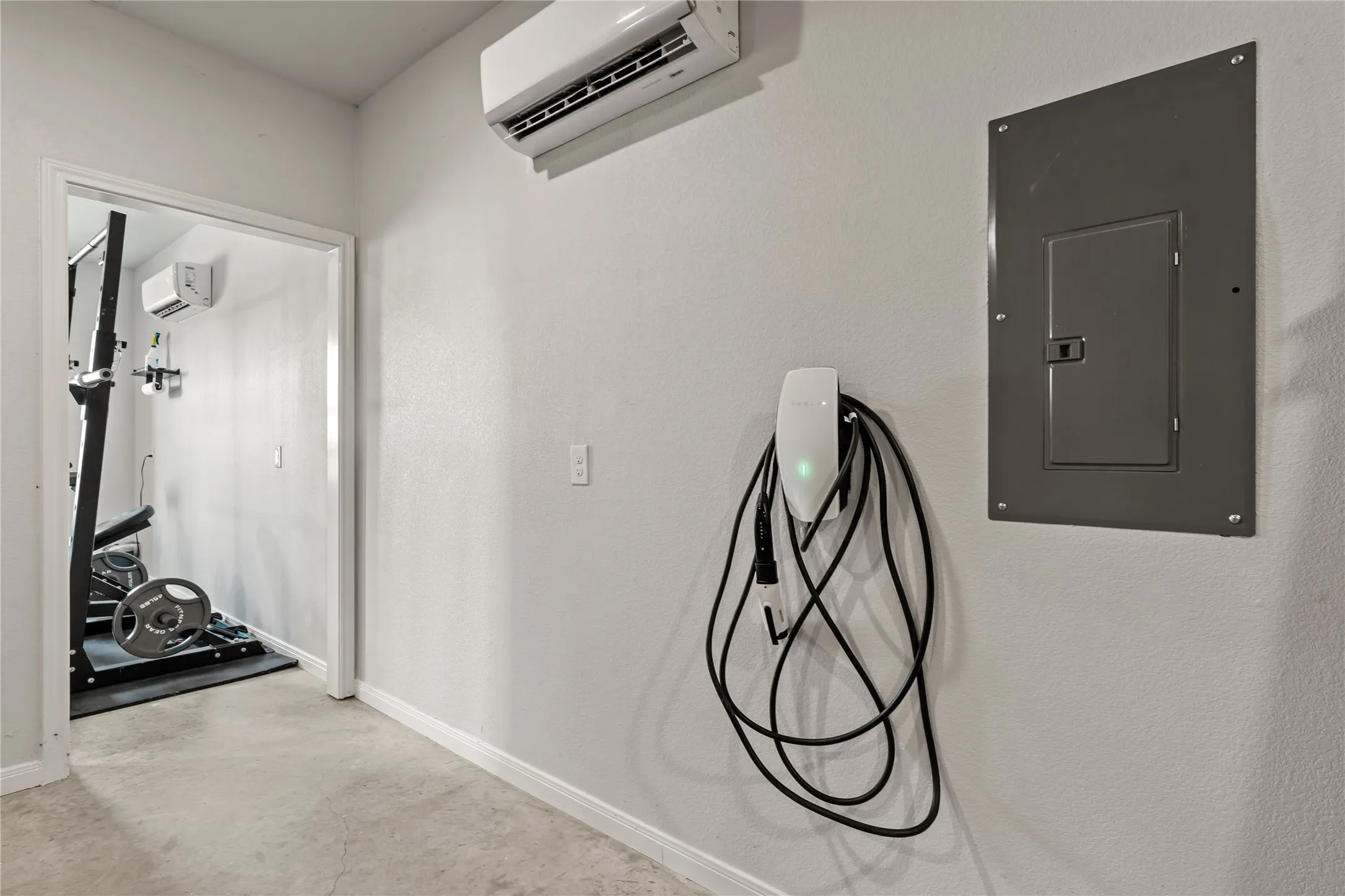 Wall-mounted electric vehicle charging station, split-system air conditioning unit, and electrical panel
