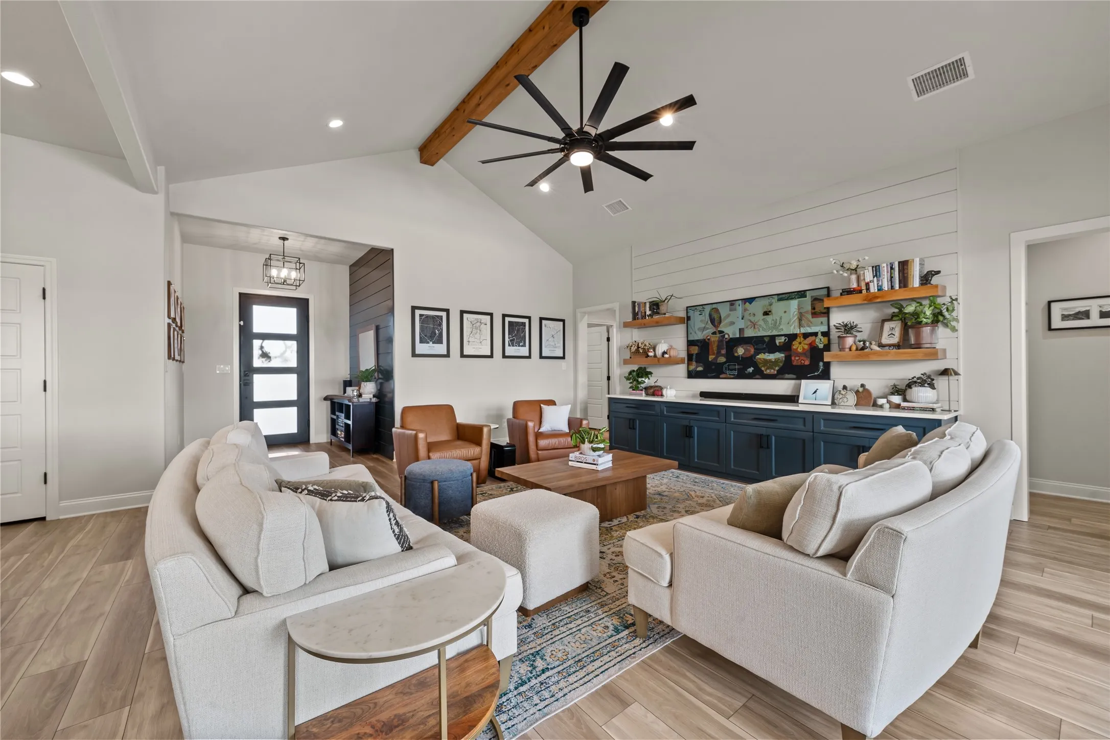 Vaulted ceiling with an exposed wood beam, wood-finish flooring, and recessed lighting