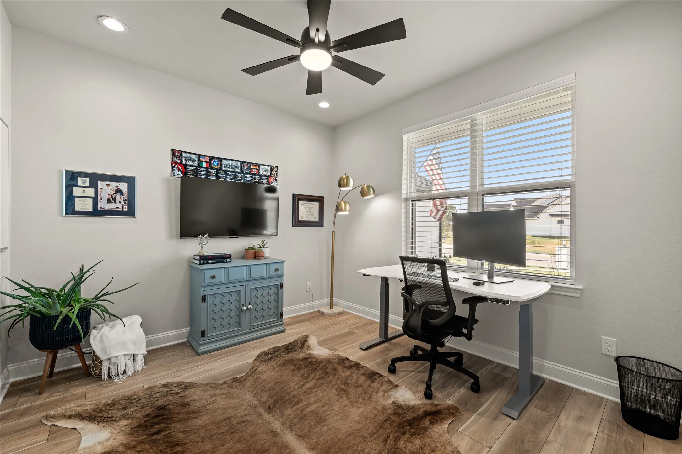 Recessed ceiling lighting, wood-finish flooring, and a ceiling fan with integrated lighting