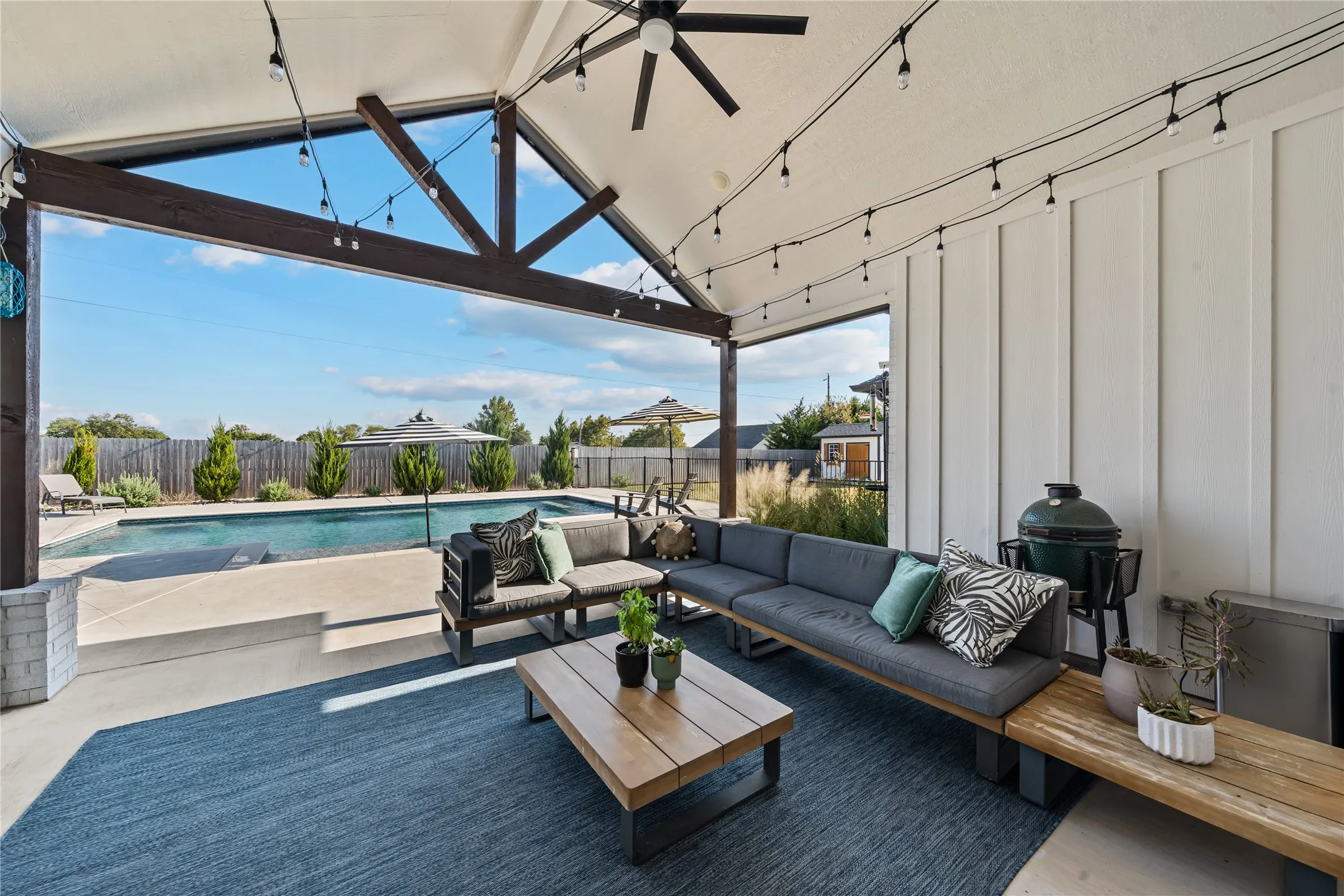 Covered outdoor patio with exposed beam ceiling, recessed lighting, and a ceiling fan