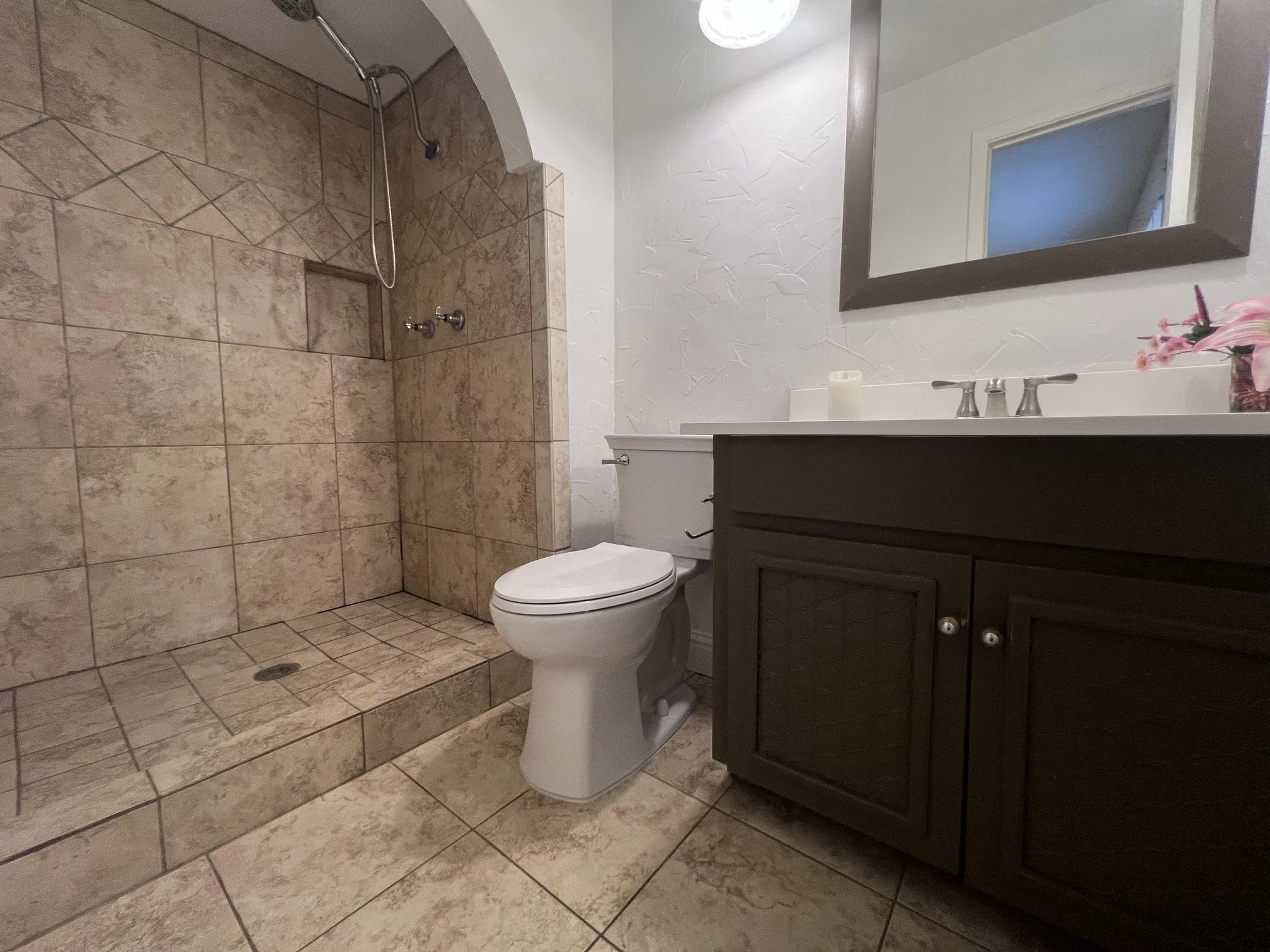 Tiled walk-in shower with integrated niche and chrome fixtures