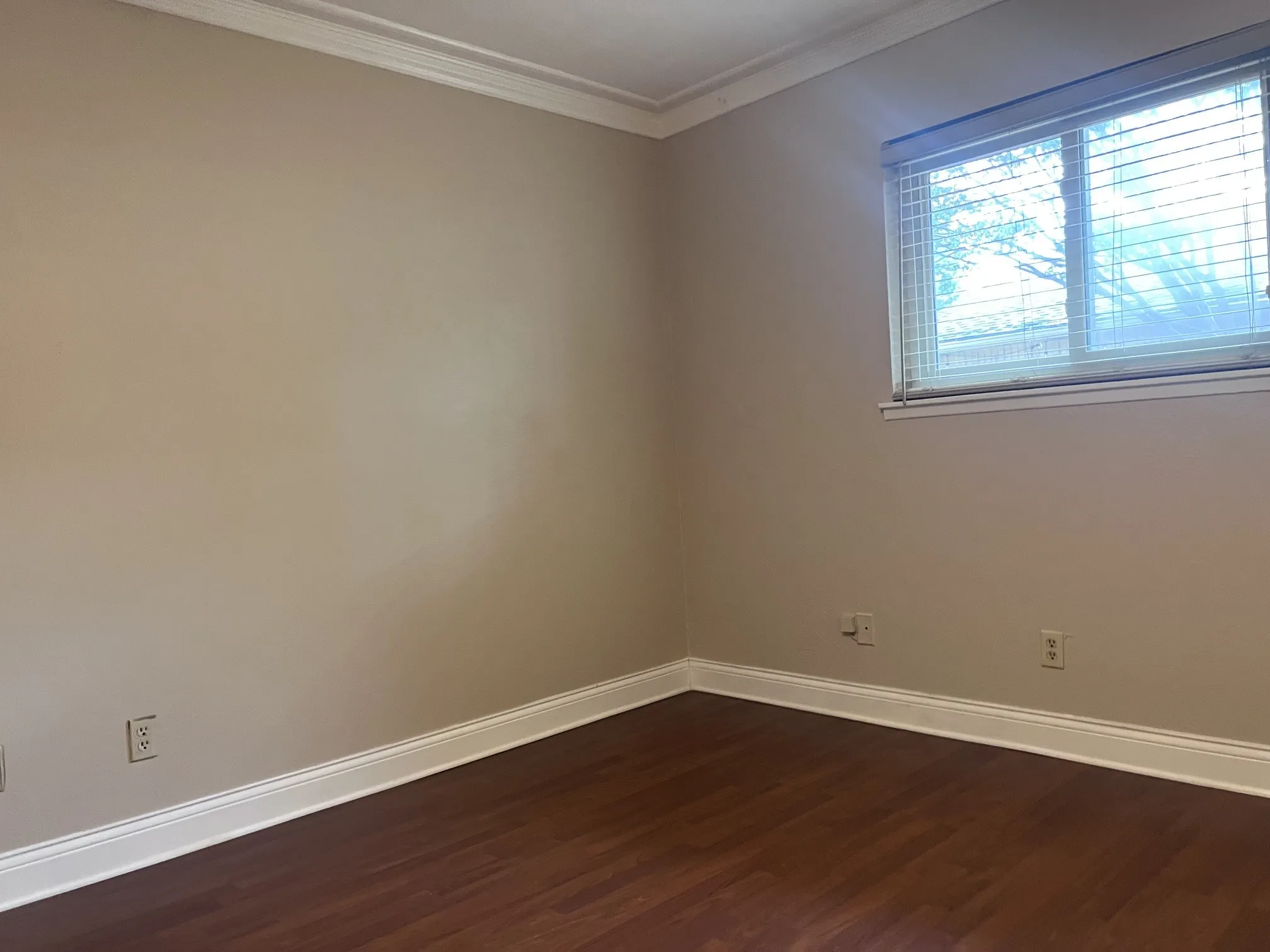 Crown molding and wood-finish flooring complement the neutral wall tones