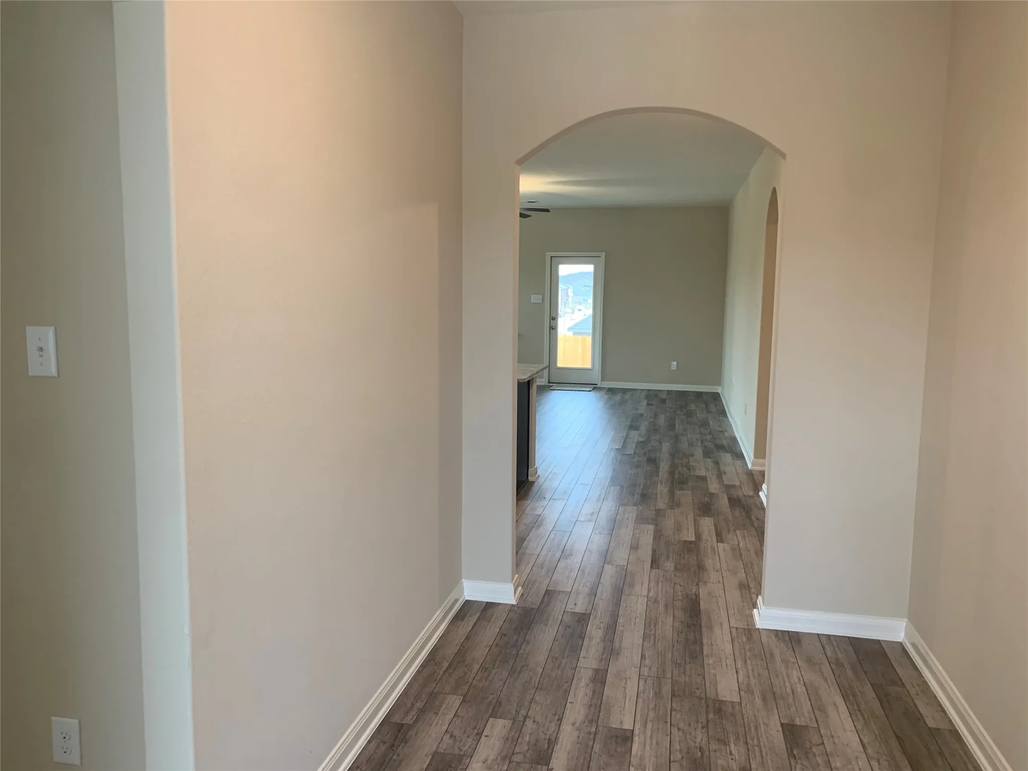 Archway entry featuring wood-finish flooring