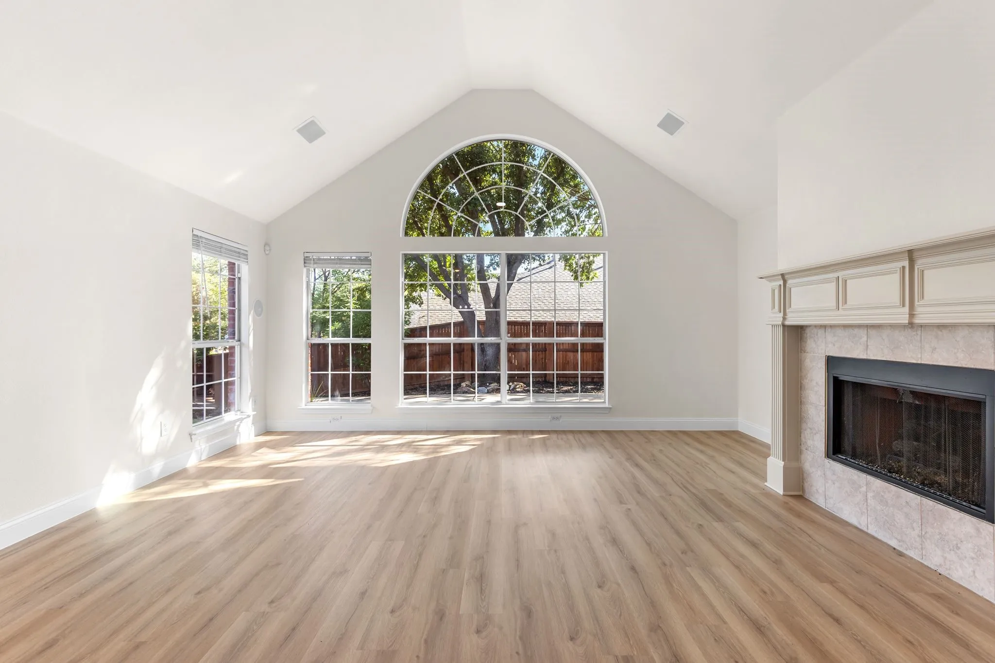 Vaulted ceiling featuring a large arched window