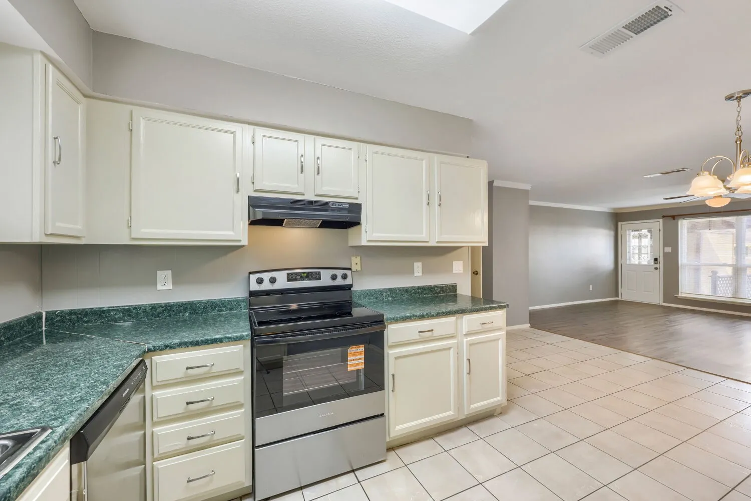 Kitchen with cream cabinetry, green stone-finish countertops, and stainless steel​​‌​​​​‌​​‌‌​‌‌​​​‌‌​‌​‌​‌​​​‌​​ appliances