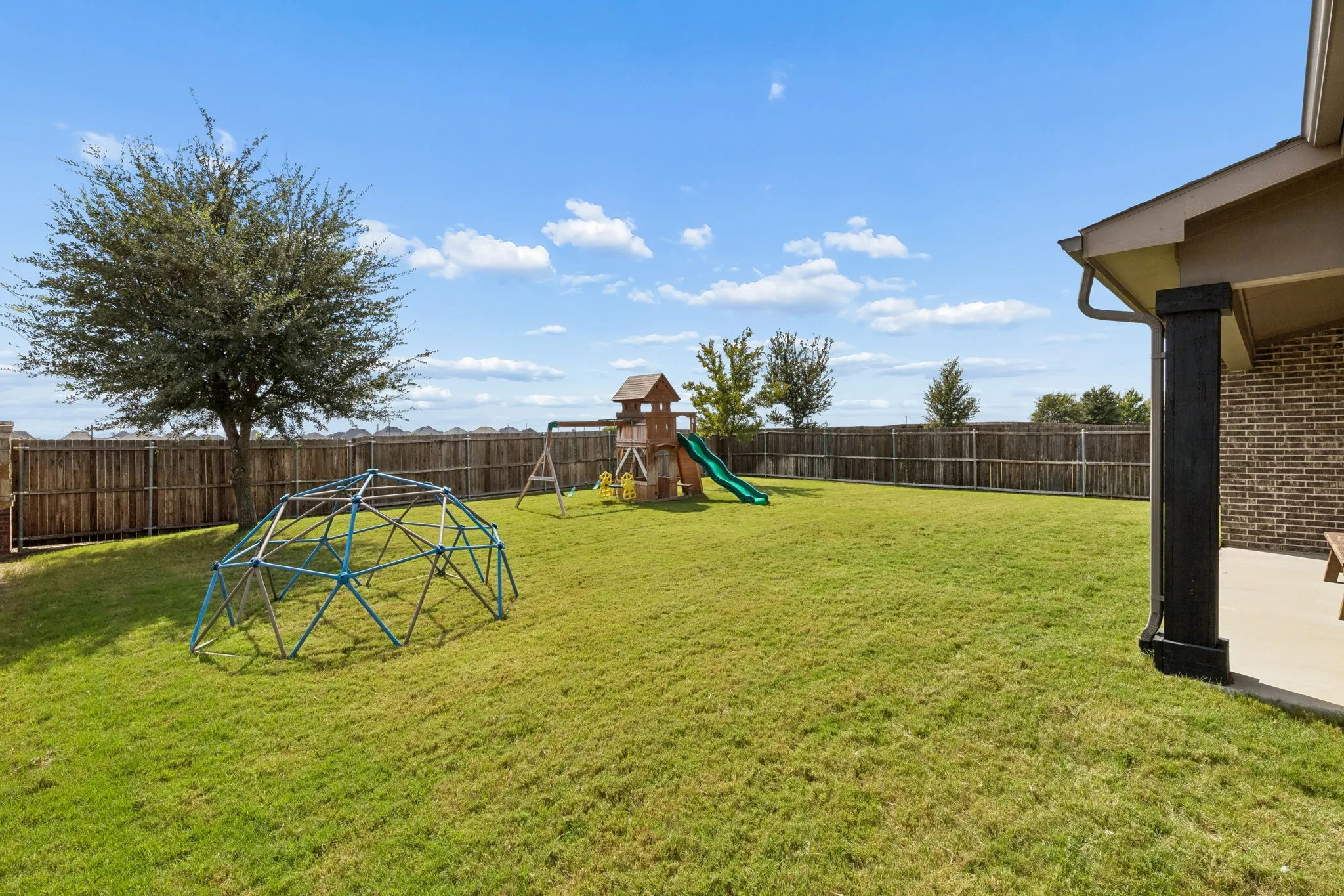Generously sized backyard offers an exceptional private setting with expansive lawn space, mature landscaping, a covered patio, and dedicated play areas. The thoughtfully landscaped grounds provide plenty of room for recreation, gatherings, pets, and outdoor living.