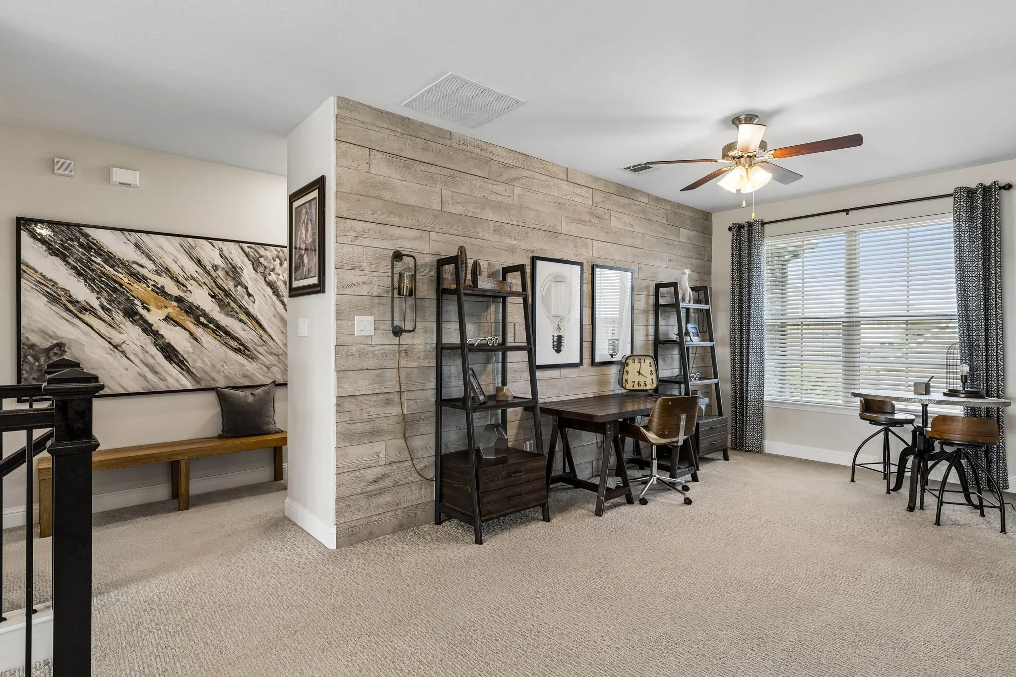 Versatile game room and flex space combines refined functionality with distinctive character, featuring a dramatic reclaimed-wood accent wall and abundant natural light. The adjoining sitting area adds flexibility for work, study, or relaxation.
