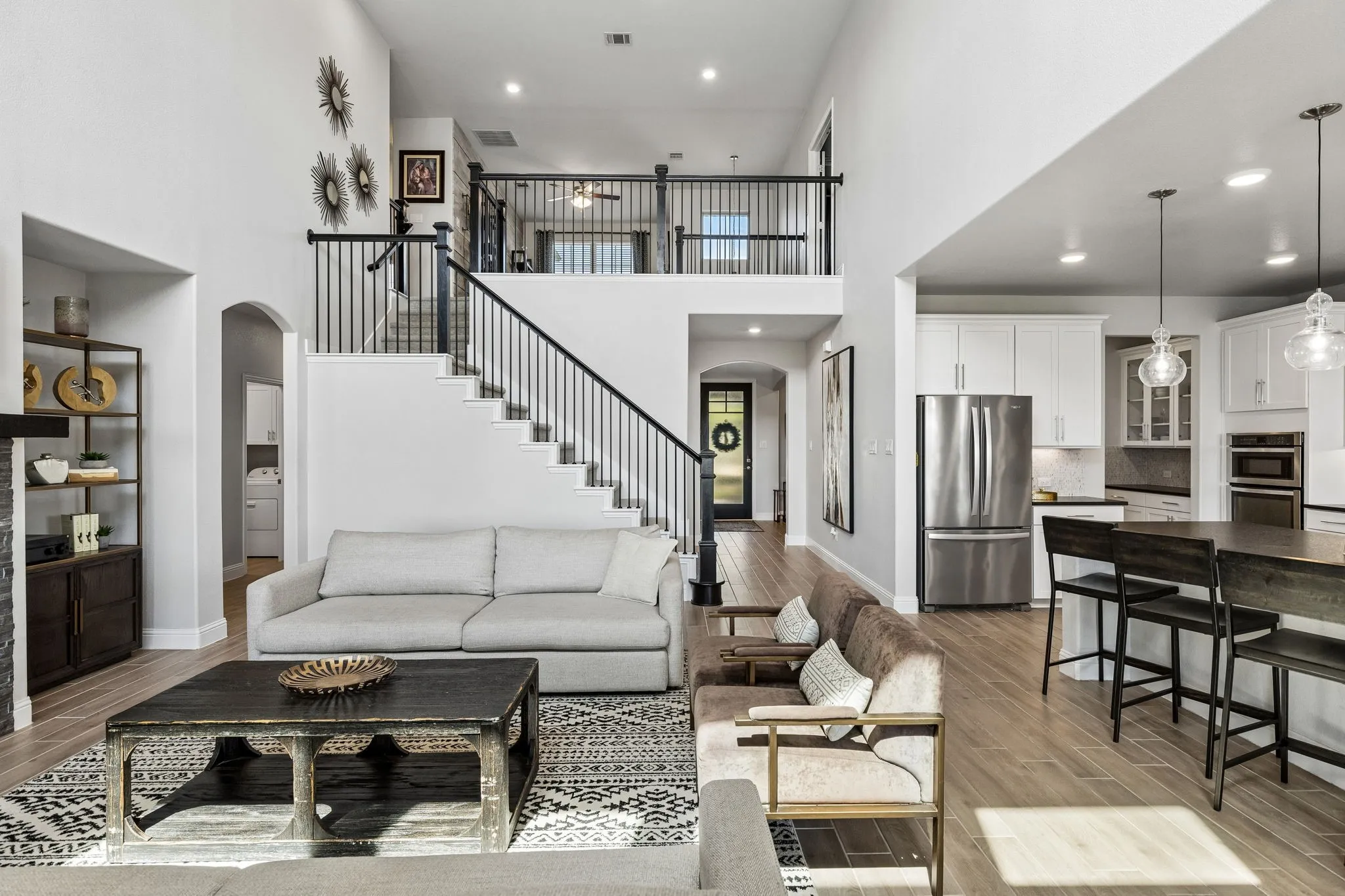 Expansive open living area showcases the home’s exceptional sense of scale, with spacious gathering areas, a dramatic staircase, fireplace, and beautifully appointed kitchen creating an ideal entertaining environment.