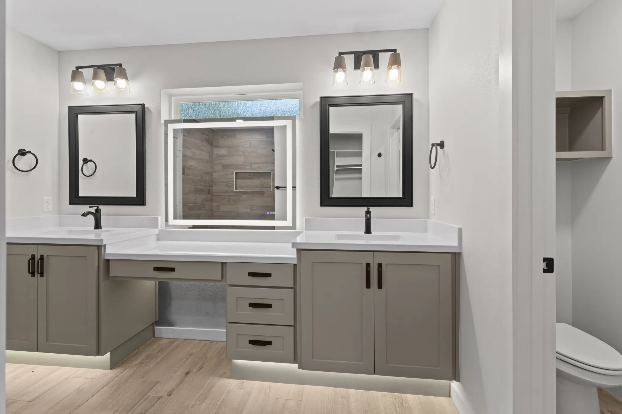 Dual vanity with white countertops, integrated sinks, and neutral cabinetry